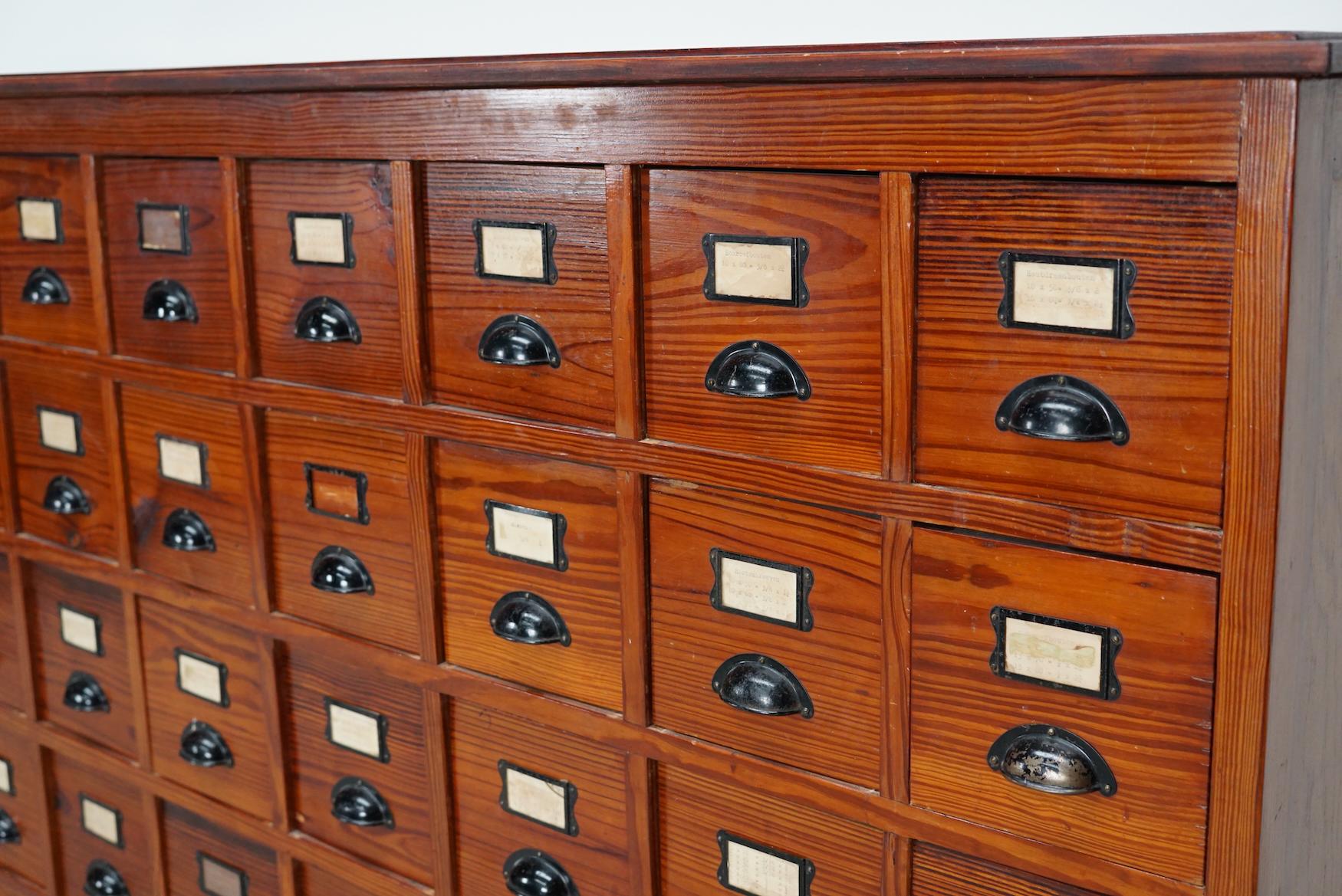 This workshop cabinet was made from pine in the Netherlands circa 1930s and it was used in a workshop. It features many drawers with nice handles and name card holders. The interior dimensions of the drawers are: DWH 41 x 15 x 15 cm.