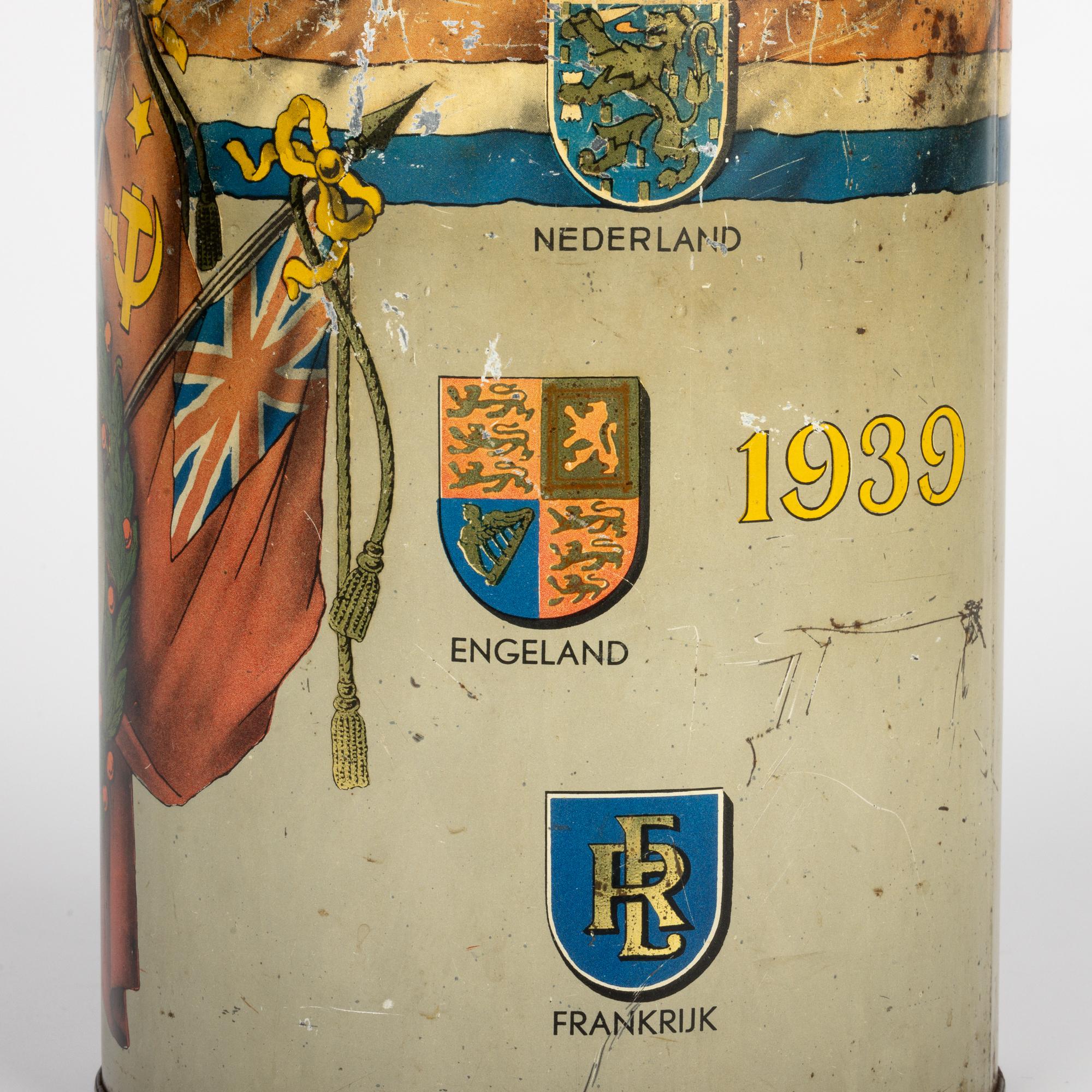 A scarce vintage Dutch ‘Je Maintiendrai’ ( I will maintain) WWII peace commemorative large biscuit tin dating from around 1945. The tin of large, tall cylindrical shape has its original tight fitting cover the body printed with black and white