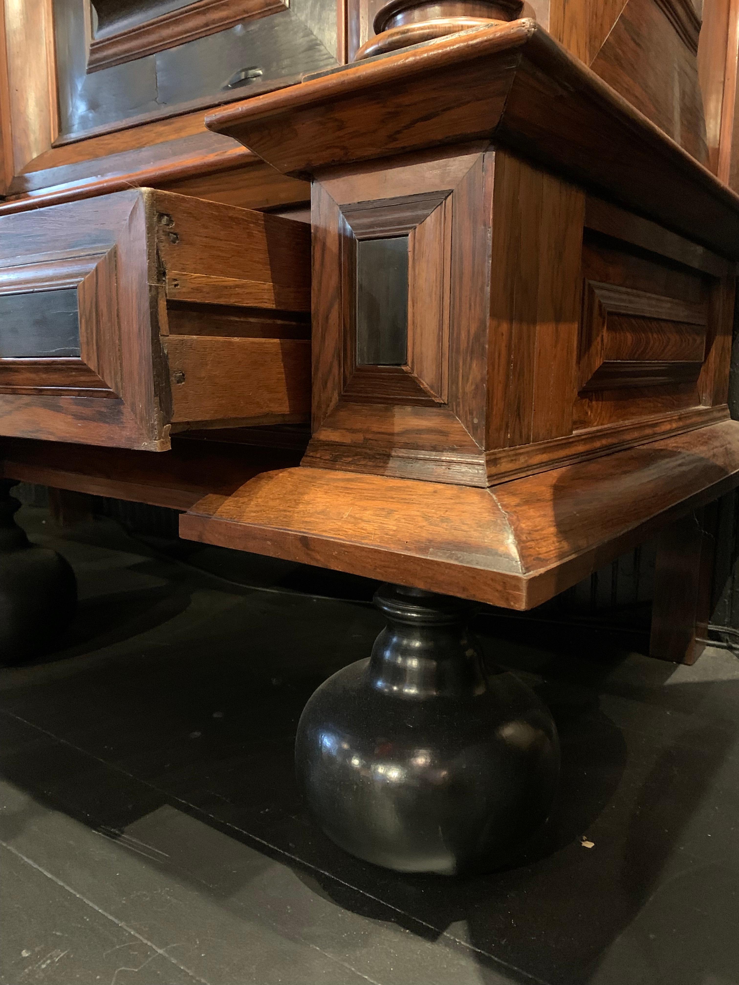 A late 17th century Dutch Kast, made of oak, with ebony and rosewood inlay and veneers sitting on period bun feet. Geometrically carved paneled doors. Hidden drawer with carved lion’s heads and brass ring pulls. Original keys and locking hardware.