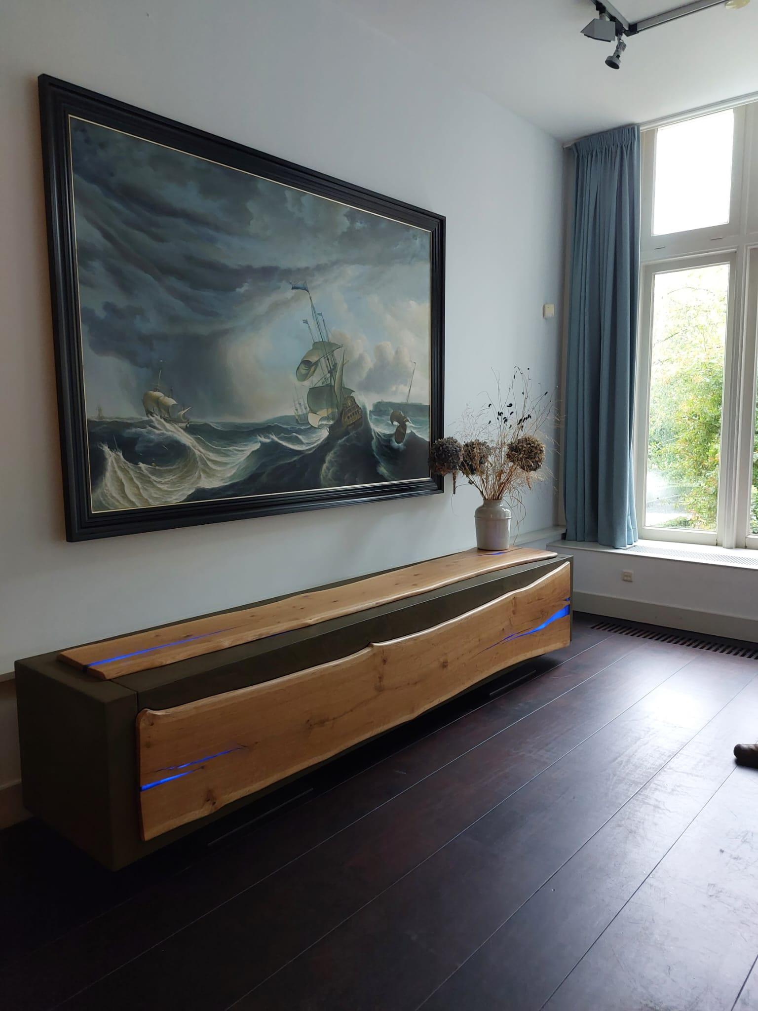 Un buffet flottant unique avec une armoire vitrée cachée.

La nature est le point de départ de la fabrication de ce meuble. La forme naturelle de
des planches de chêne intactes, où le buffet suit la forme naturelle des planches, est
finition en