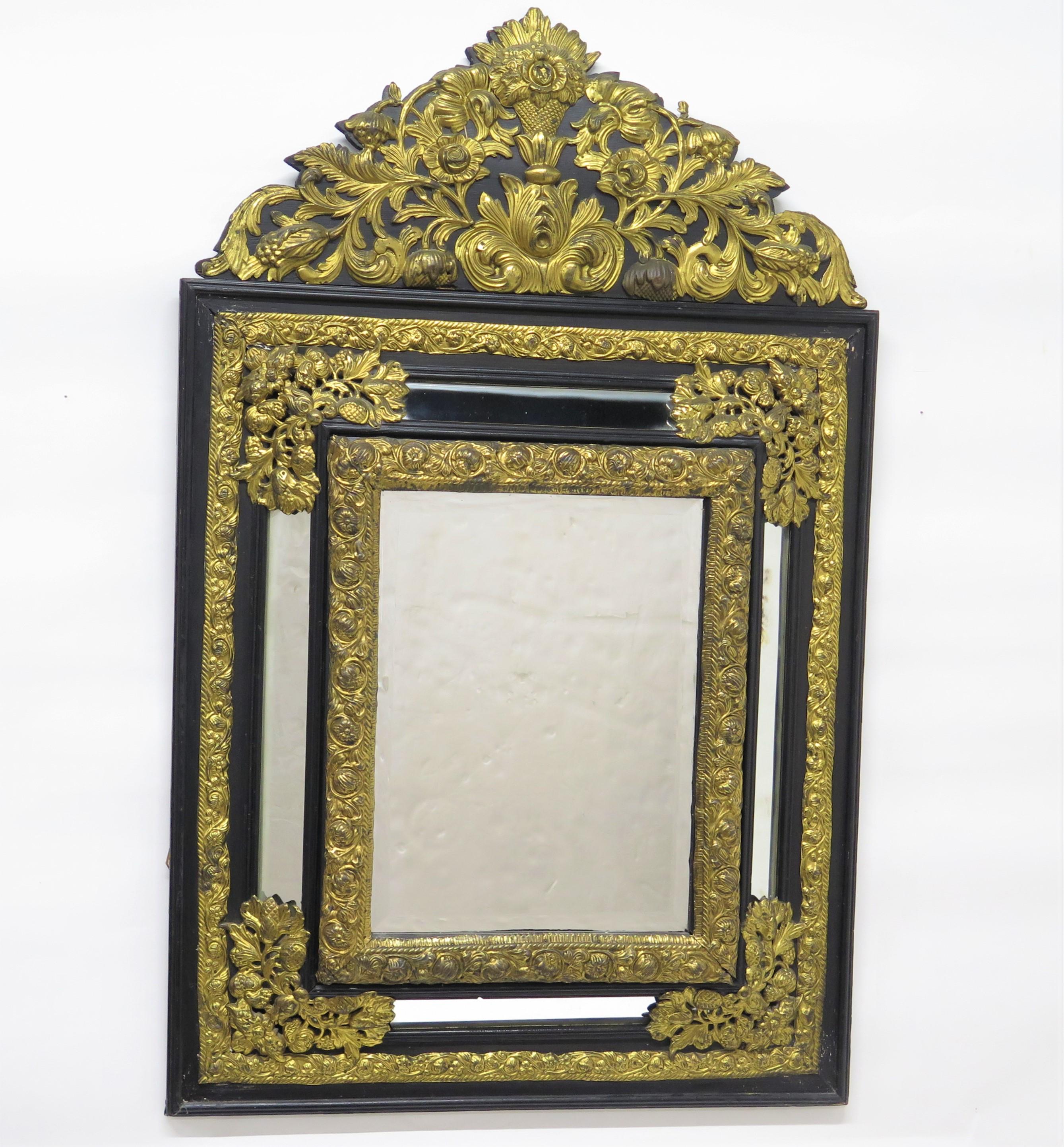 a Dutch ebony and repoussé brass mirror / looking glass with floral motifs, beveled edge glass in the center, Holland (The Netherlands), 19th century