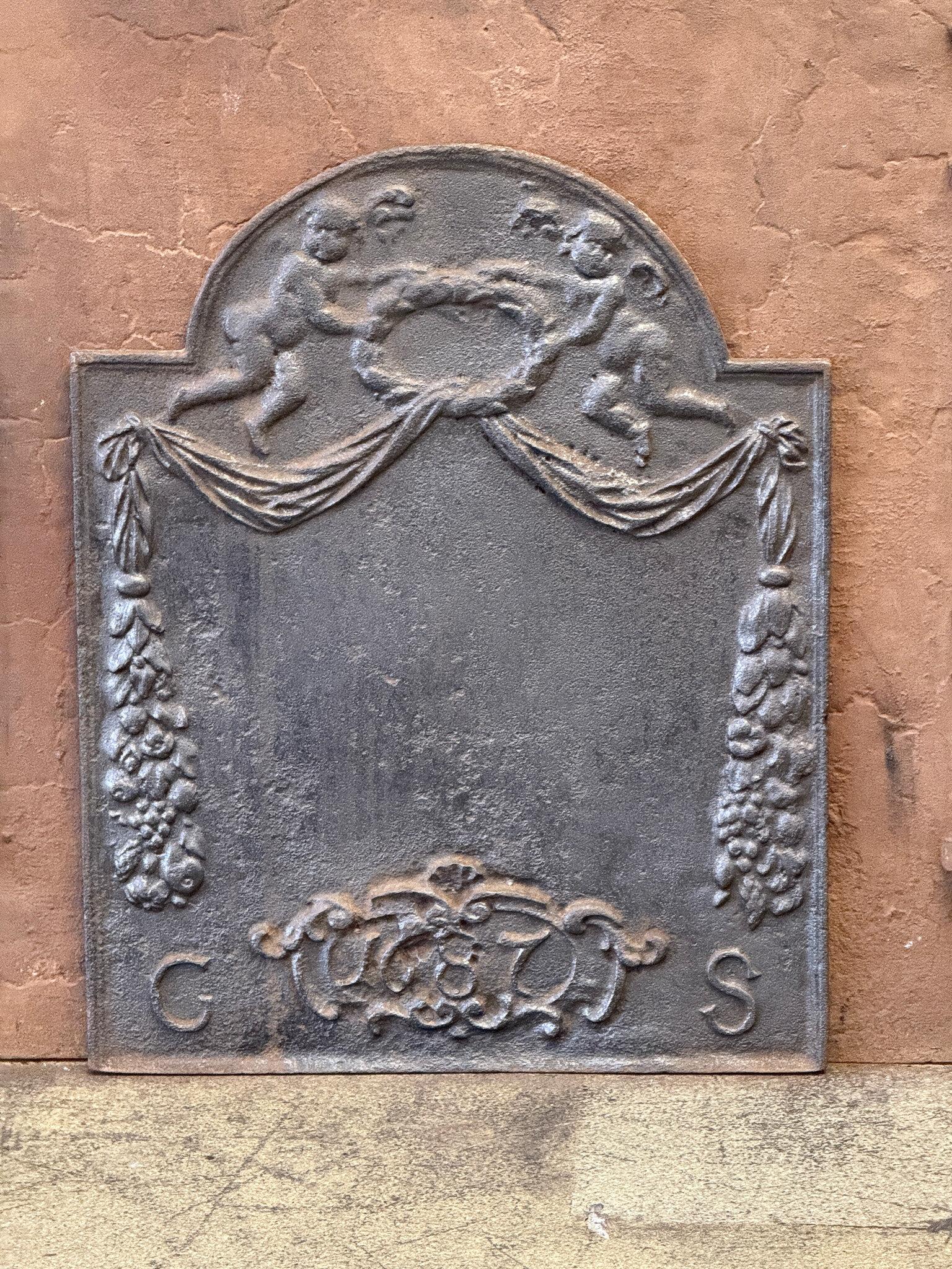 17th century Dutch Louis XIV Period fireback / backsplash depicting an allegory of peace. The two angels are holding a laurel wreath, symbol for victory, in their hands.

The fireback is black/pewter colored. The condition is good, with no cracks.