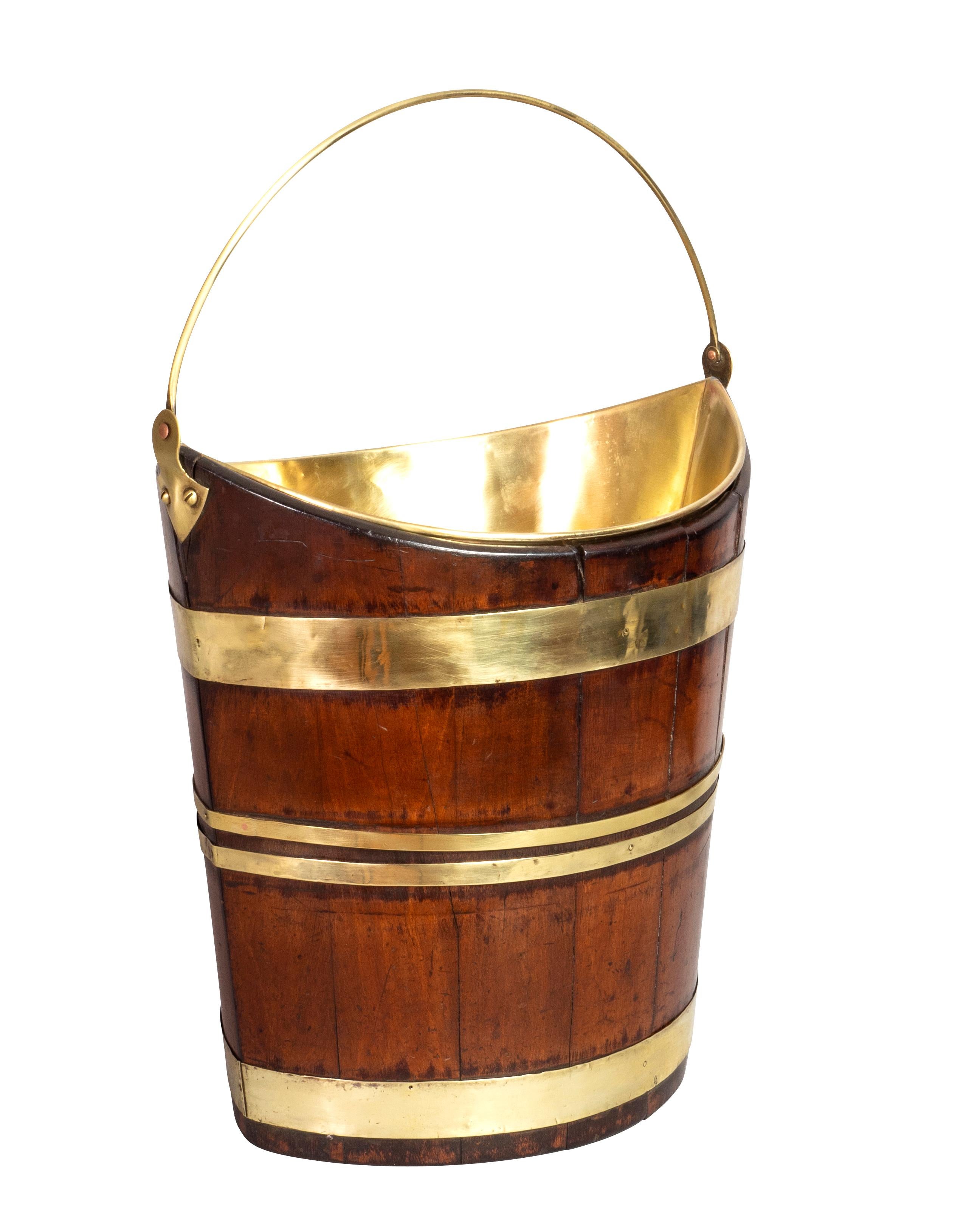 Oval with brass liner and handle, conforming body with brass strapping.