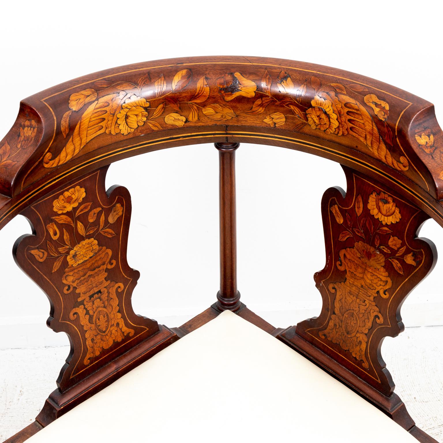 Dutch mahogany corner chair with newly upholstered seat, curved back splats, and cabriole legs on ball and claw feet. The piece also features lightwood marquetry ornamented with flowers and shellwork. Please note of wear consistent with age