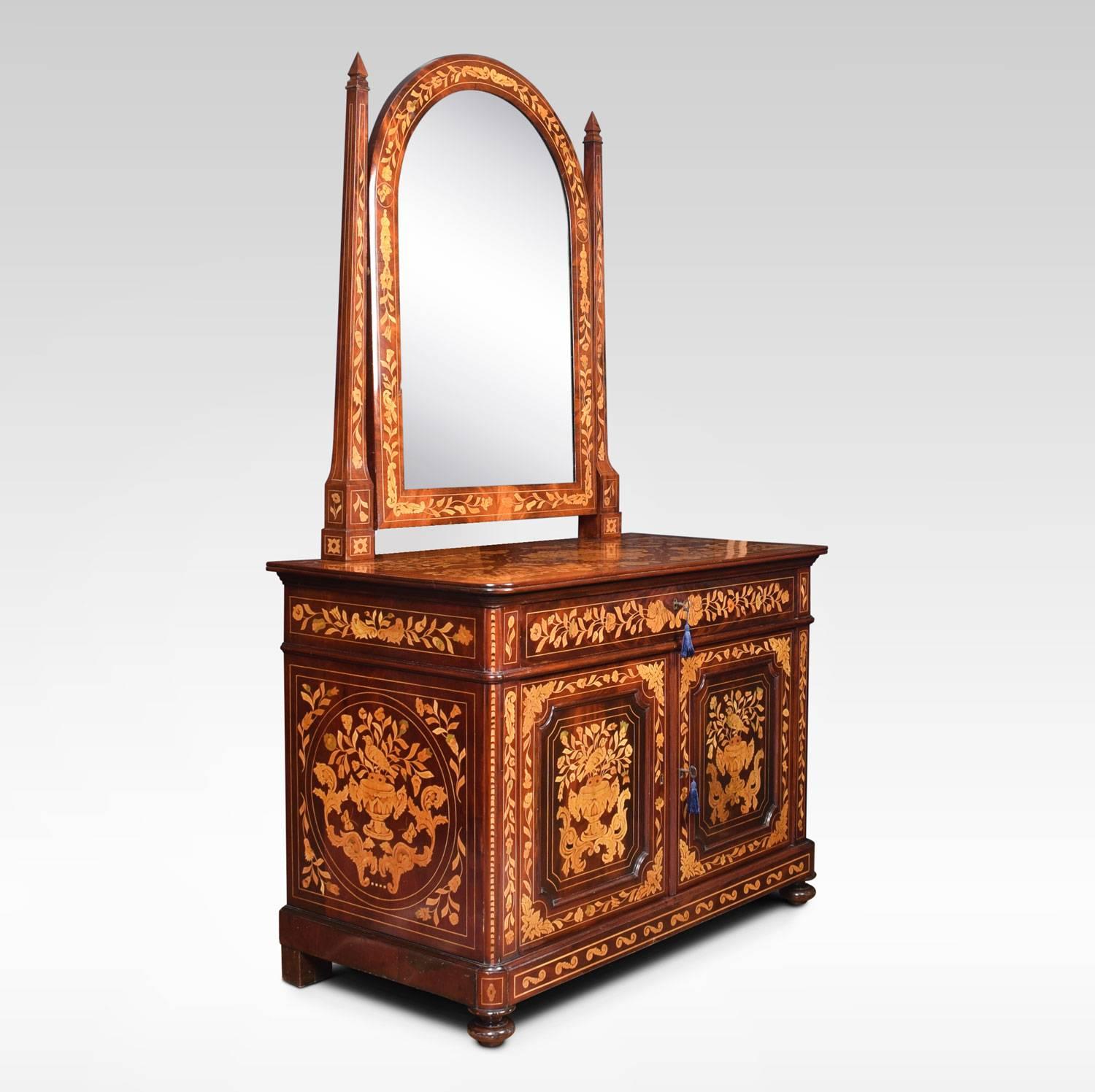 A Dutch mahogany and marquetry inlaid dressing table the arched mirror between tapered uprights to the base section fitted with long freeze drawer over a pair of cupboard doors with floral, bird, and urn marquetry, opening to reveal shelved