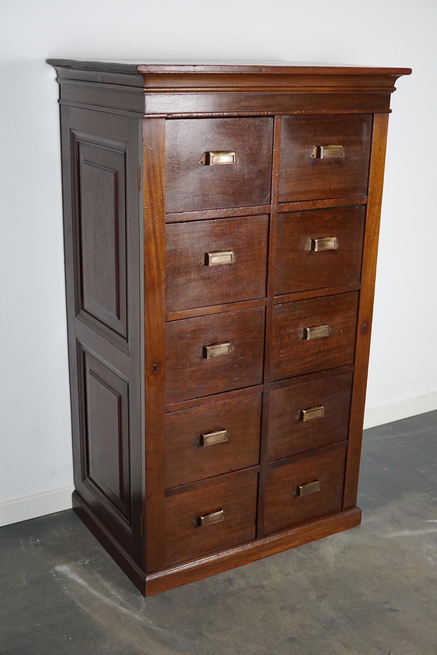 This vintage mahogany bank of drawers dates from the 1920/1930s and was made in the Netherlands. It features a mahogany frame, drawers with mahogany fronts and brass handles. The drawers can be locked but there are no keys included.