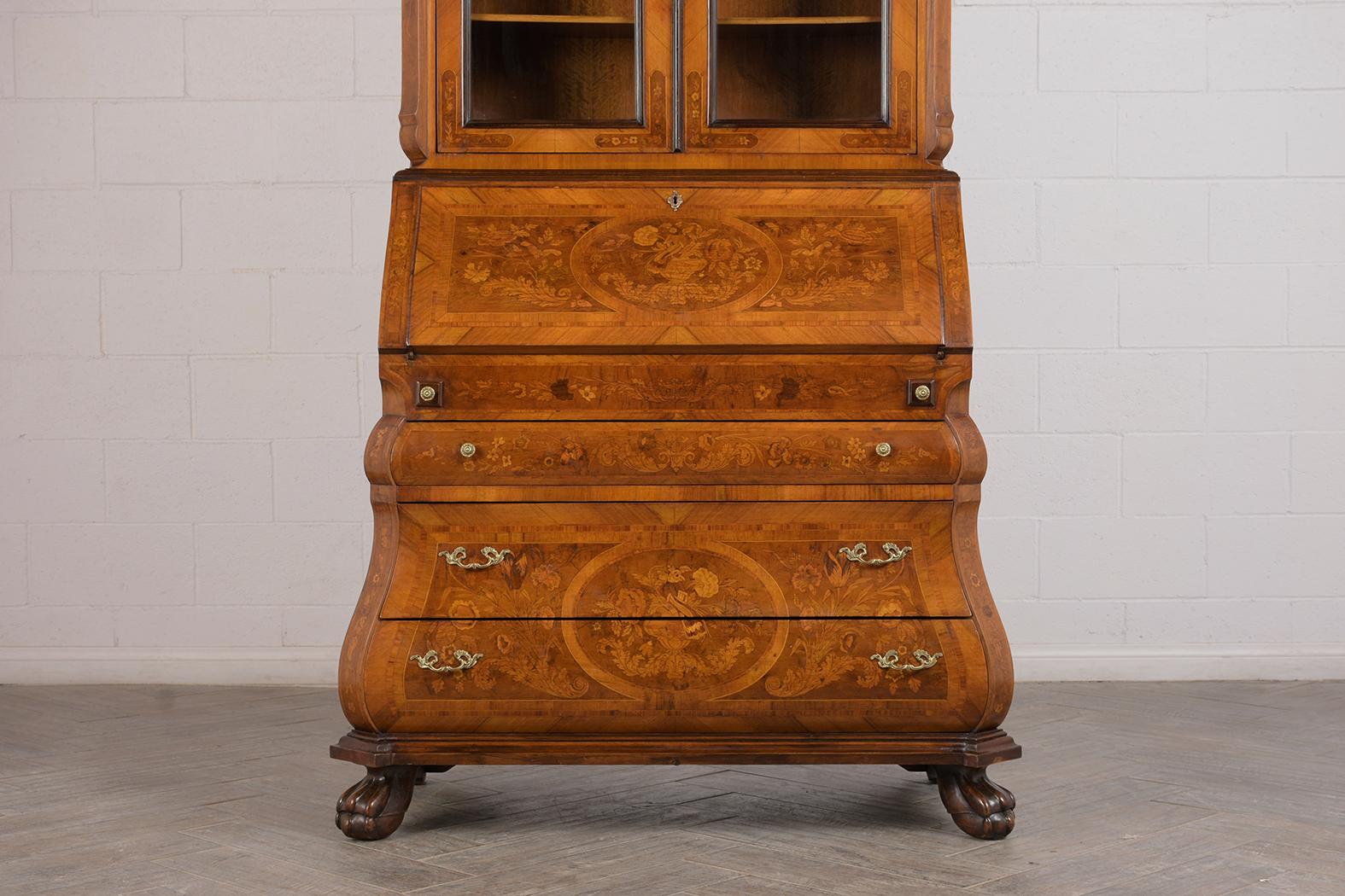 This antique Dutch bookcase / secretaire has been restored with its original mahogany finish. This remarkable piece has a unique inlaid over the entire piece. The top has large carved seashell at the center, two carved doors with original glass and