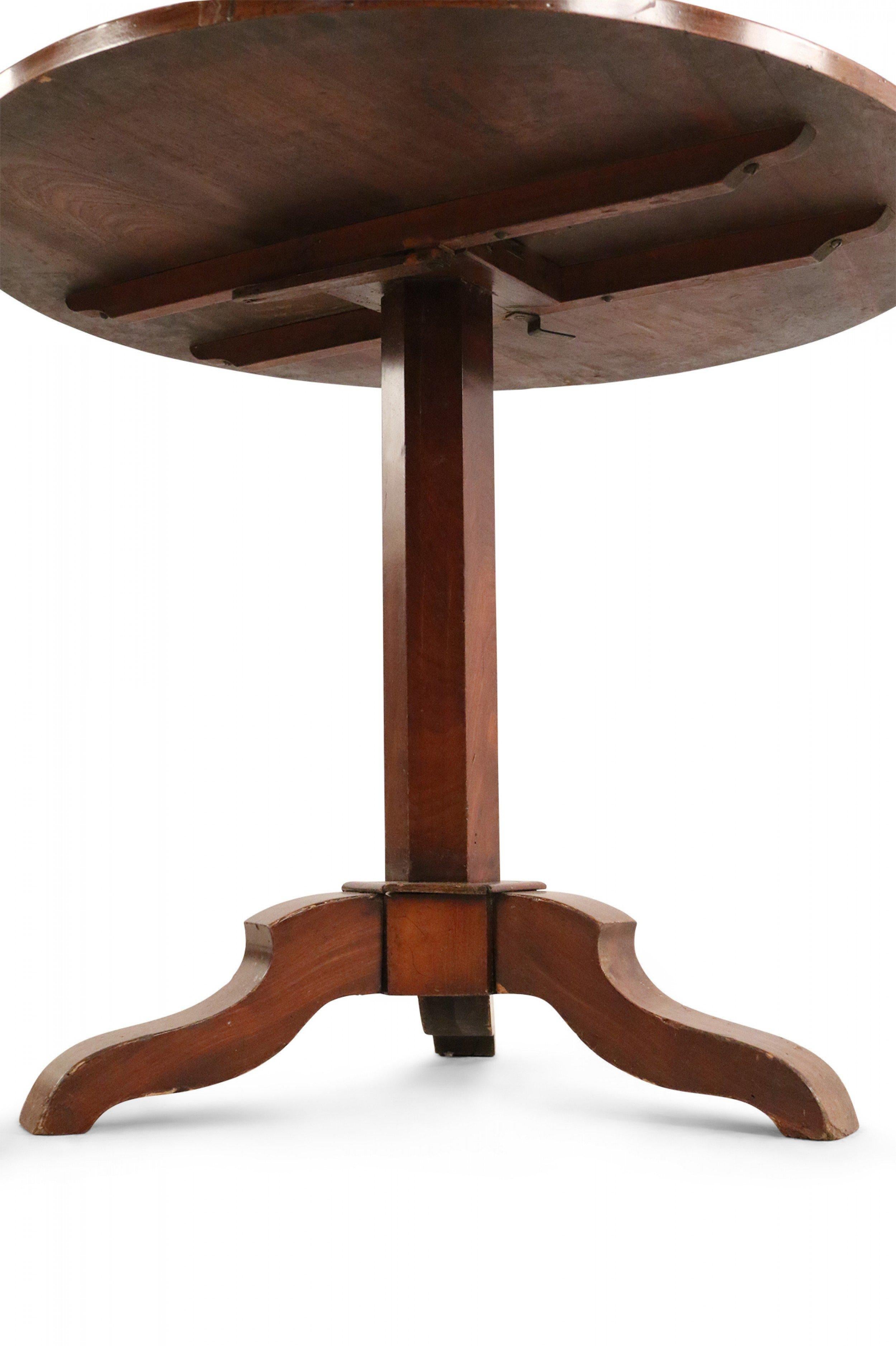 Dutch (19th century) mahogany flame veneer round tilt-top table with a center floral marquetry inlaid medallion supported on a tripartite base with scalloped legs.
       