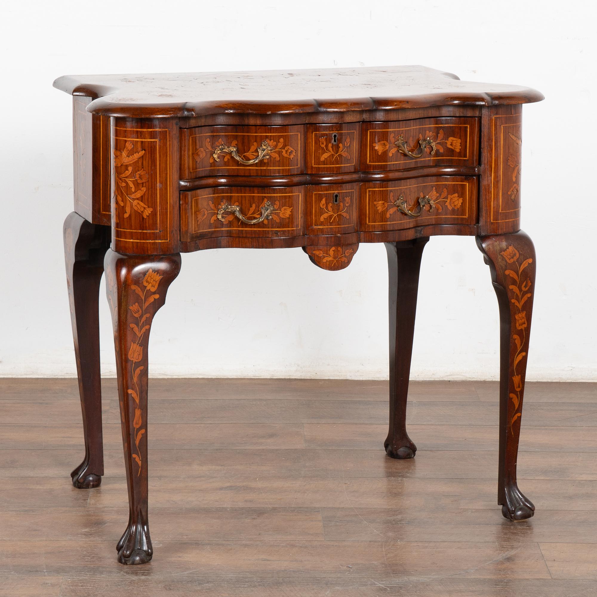 Elegante table d'appoint en chêne marqueté hollandais avec deux tiroirs en serpentin reposant sur de longs pieds cabriolet marquetés.
Veuillez agrandir les photos pour apprécier la richesse des bois de placage avec des incrustations détaillées de