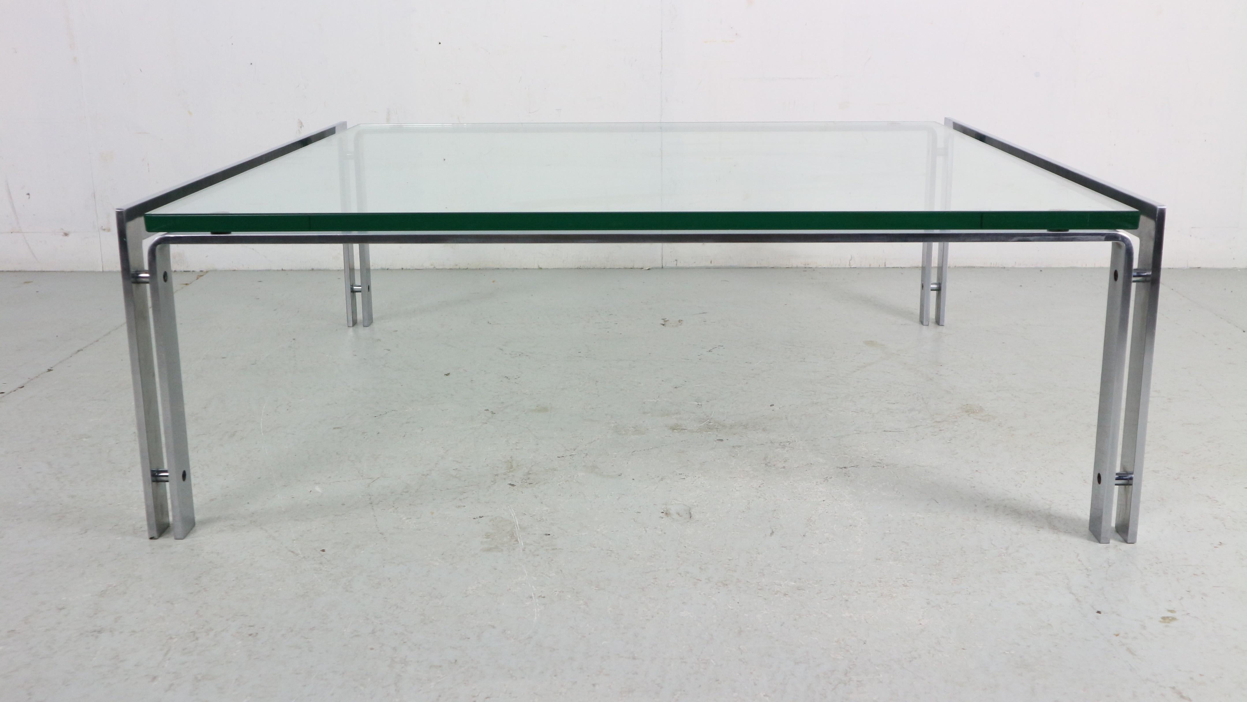 Mid-Century Modern period large coffee table designed by Hank Kwint for Metaform manufacture in The Netherlands, 1970.
This coffee table has a frame of stainless steel that supports a thick clear glass top. 
Over all the glass top has no