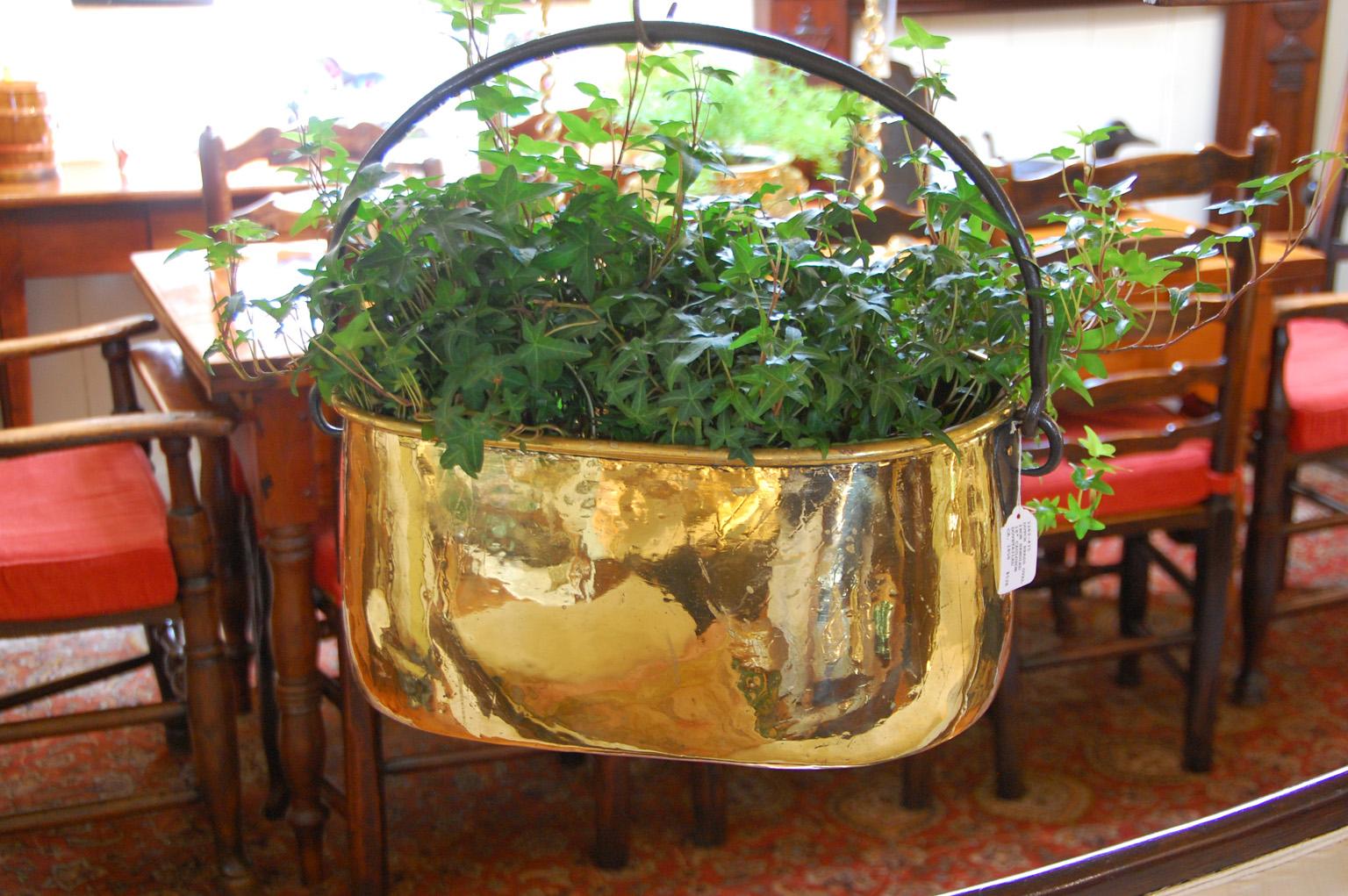 Dutch mid 19th century heavy quality oval brass cooking cauldron with swing wrought iron handle. This 18 inch dovetailed cauldron has remnants of incised line decoration, but only hints of it, as with polishing most has worn away. Today cauldrons