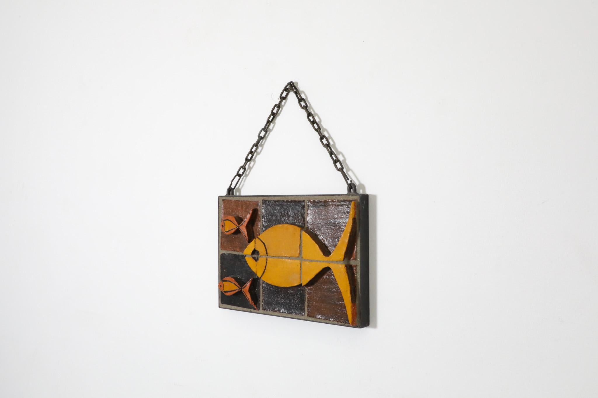 Un hermoso mosaico alemán de mediados de siglo que utiliza una combinación de azulejos de cerámica de vivos colores y un fondo de hormigón para crear esta cautivadora escena en relieve de peces nadando Ruscha. El mosaico está enmarcado en hierro