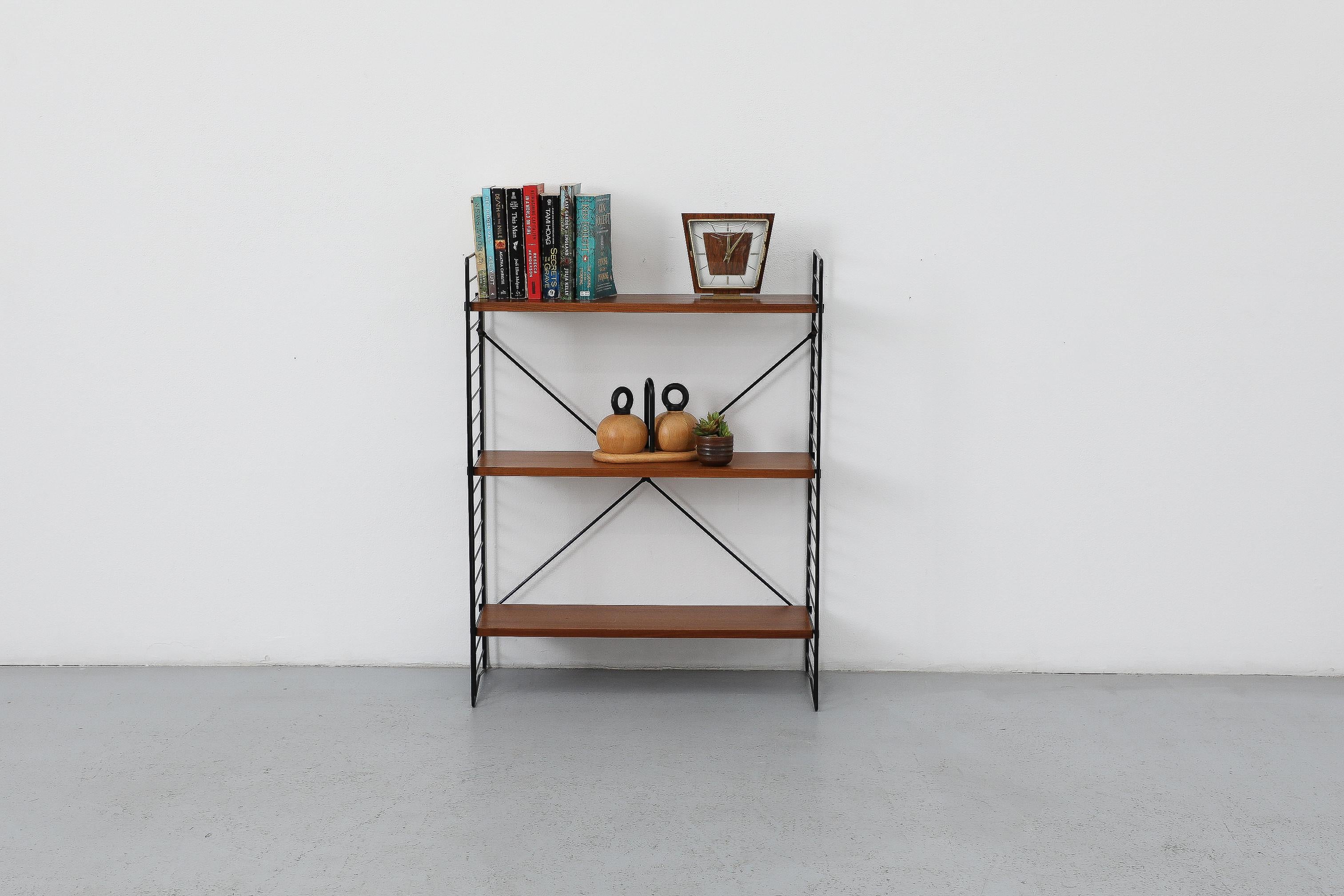 Scaffale a sezione unica di Jan Van Der Togt per Tomado. Dotato di tre ripiani in teak che poggiano su una delicata struttura in filo di ferro smaltato nero. L'unità è in condizioni originali con alcuni segni di usura, leggeri graffi e piccole