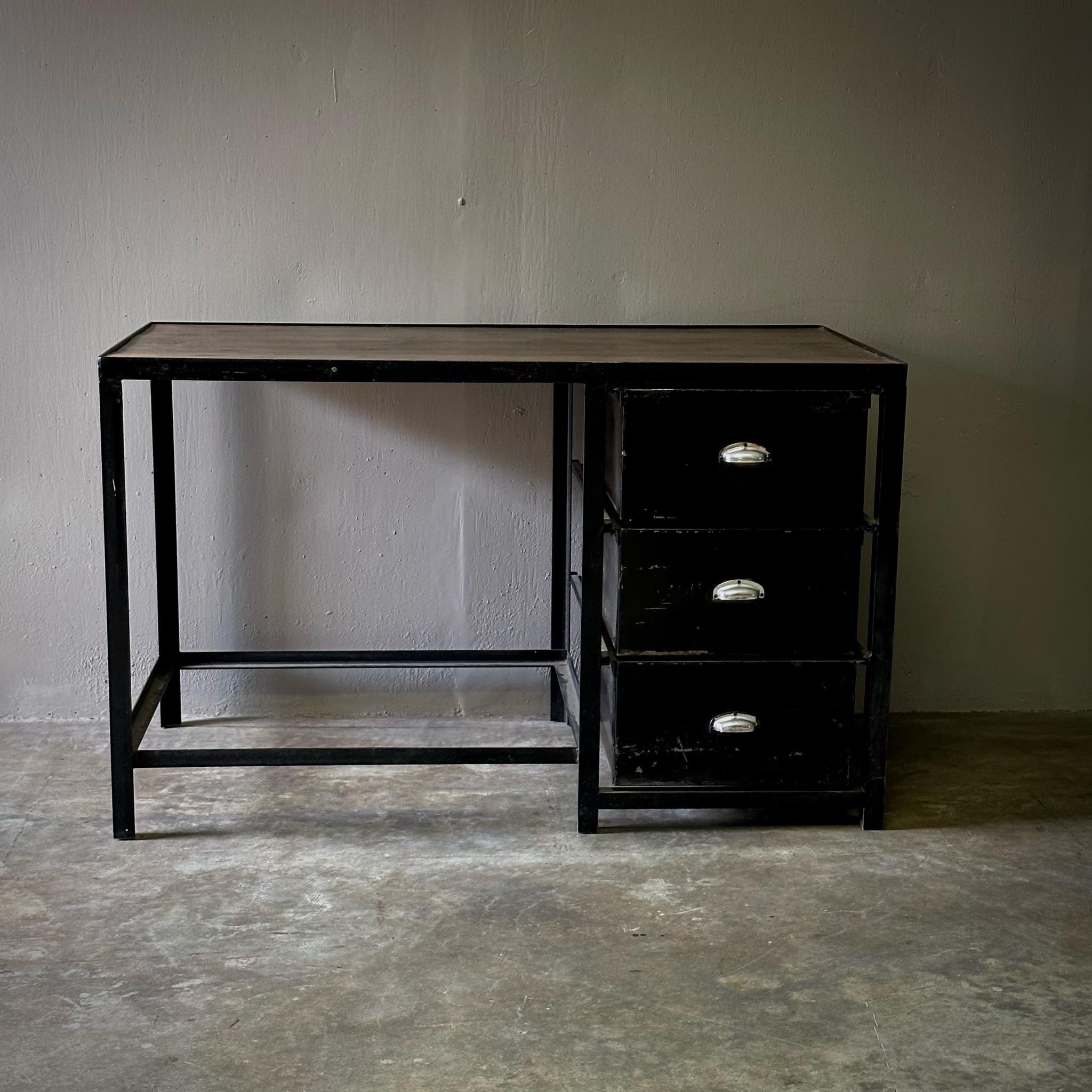 Dutch midcentury industrial black metal desk with three cupped ring drawers and rectangular wood top. A handsome work of midcentury industrial design with cool and utilitarian design accents. 

Netherlands, circa 1960

Dimensions: 51.2W x 27.6D