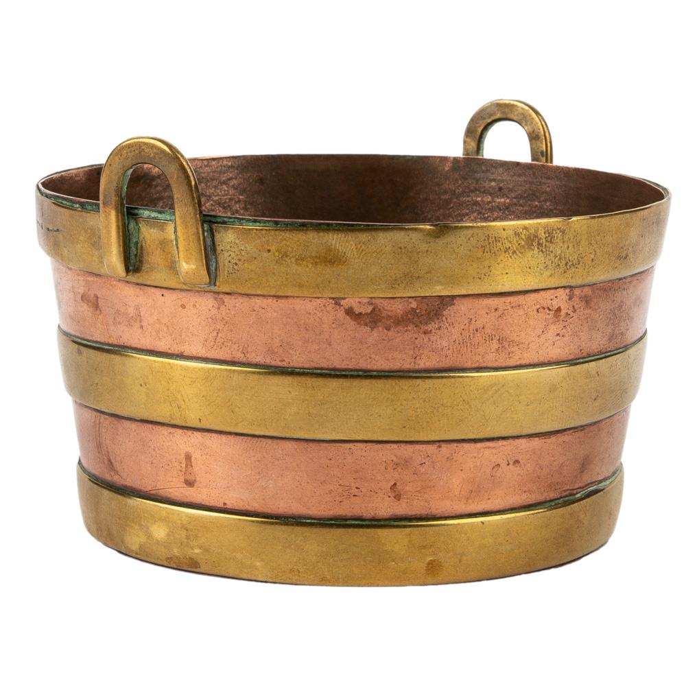 This charming miniature Dutch copper basket accentuated with brass straps and  applied with upright brass handles is from the late 19th century. Perfect for trinkets or other small objects, on a desk or dresser. With maker's mark at the base.  

2 x