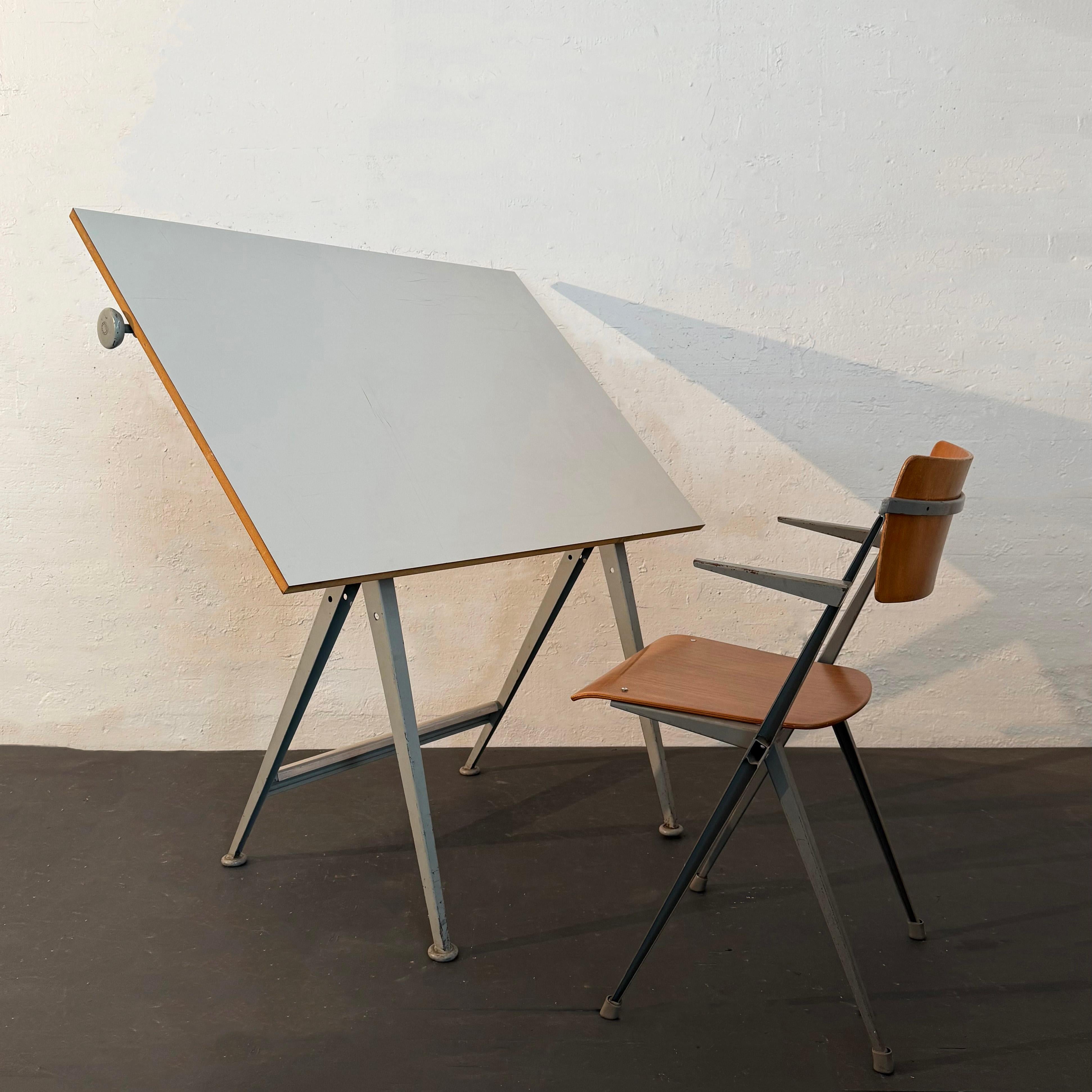 This drafting table and chair set was designed by Dutch designers Wim Rietveld and Friso Kramer for Ahrend de Cirkel in 1963.  This sturdy mid-century modern drafting set is a distinctive and timeless design. The table features a gray enameled steel