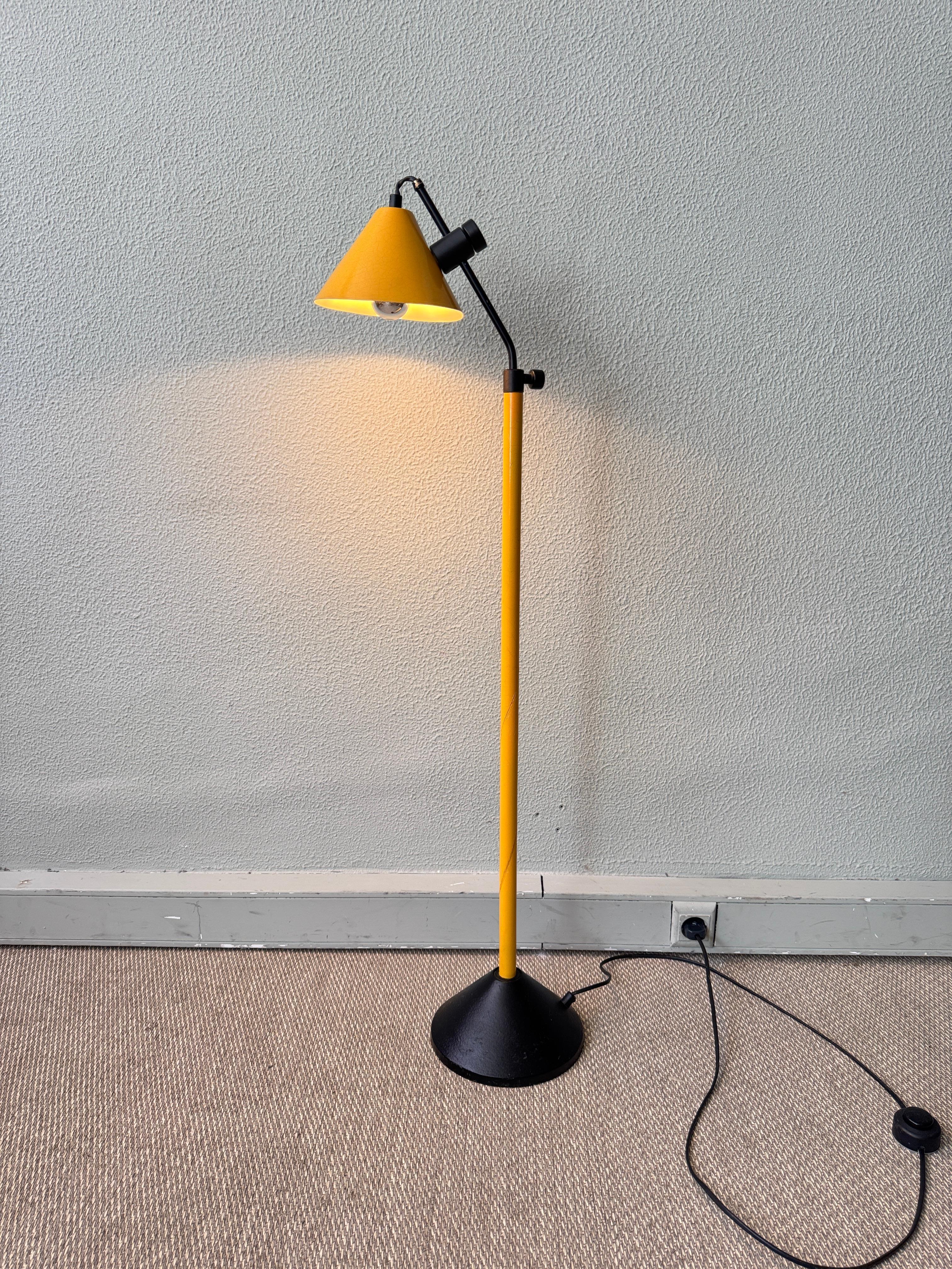 Diese verspielte und doch raffinierte holländische Stehlampe aus den 1980er Jahren vereint kräftige Primärfarben und starke Geometrie in einem funktionalen Design. Die Leuchte besteht aus einem leuchtend gelb lackierten Metallstiel und einem