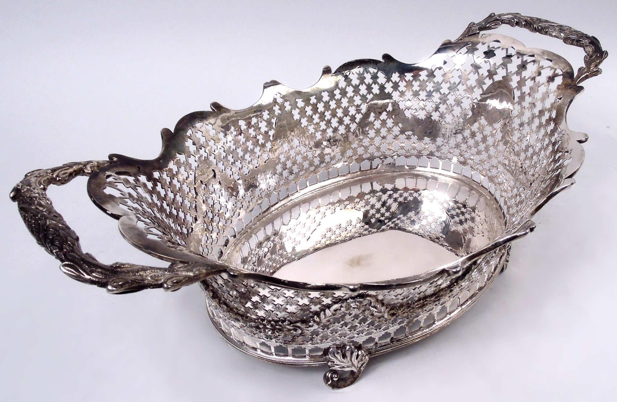 Ciotola neoclassica olandese in argento, 1879. Pozzo ovale solido. I lati comprendono una ghirlanda floreale con cesto di fiori in perline e rondelle di cervo applicate a un pannetto di fiori aperto; colonnato aperto in basso. Maniglie finali a