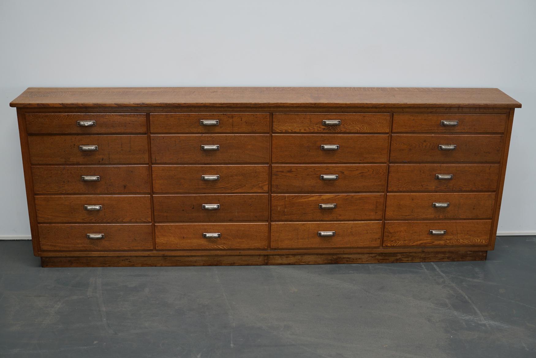 This apothecary / filing cabinet was produced during the 1930s in The Netherlands. This piece features 20 drawers. The interior dimensions of the drawers are: DWH 25 x 55 x 13 cm and the top four 25 x 55 x 8 cm.