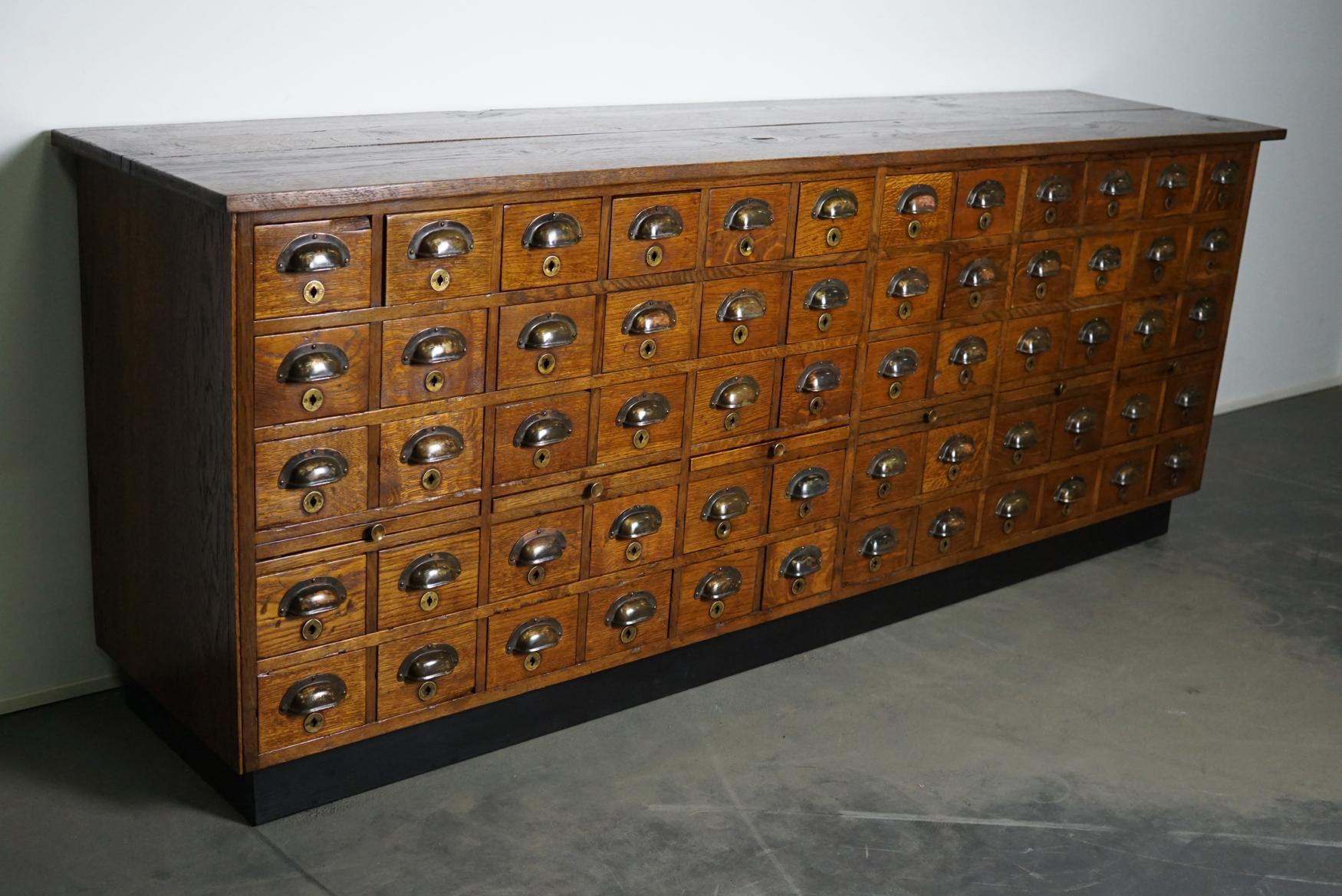 This apothecary cabinet was made circa 1930s in the Netherlands. It features 60 drawers with nice brass handles. The interior dimensions of the drawers are: D x W x H 36 x 13 x 4.5 / 9 cm.