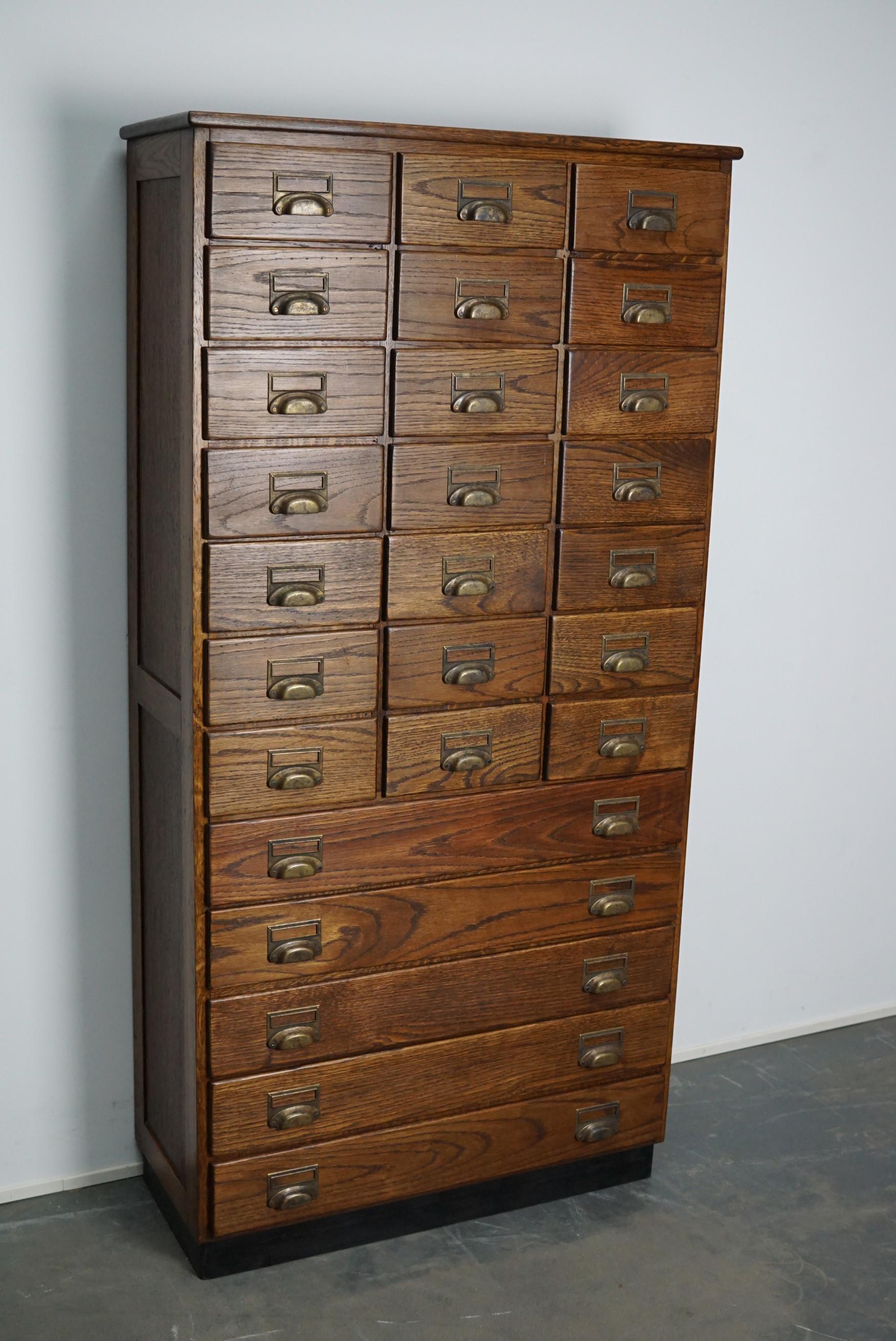 This apothecary cabinet was made circa 1930s in the Netherlands and restored at a later period in time. It features 26 drawers with nice brass handles. The interior dimensions of the drawers are: D x W x H 23 x 19 x 8.5 cm and 28 x 69 x 9 cm.