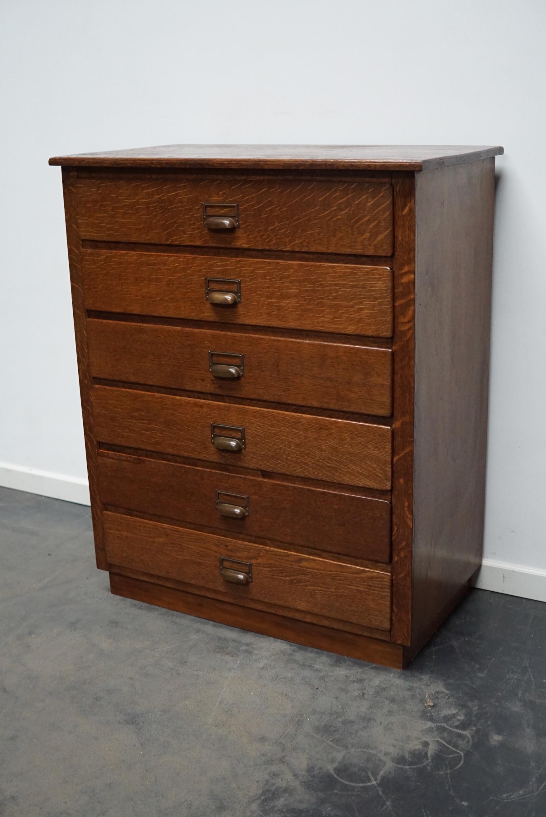 This apothecary cabinet was designed and made from oak circa 1930 in the Netherlands. It features 6 decent sized drawers with brass hardware. The inside of the drawers measure: DWH 36 x 32 x 14 cm.