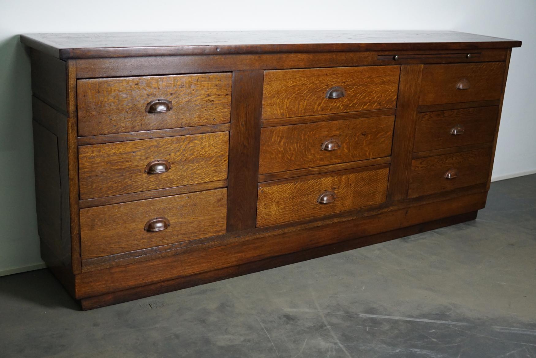 This apothecary cabinet was made circa 1930s in the Netherlands. It features 9 drawers with nice metal handles. It is made from oak and it remains in a very good condition. The interior dimensions of the drawers are: D x W x H 30.5 x 48.5 x 13 cm