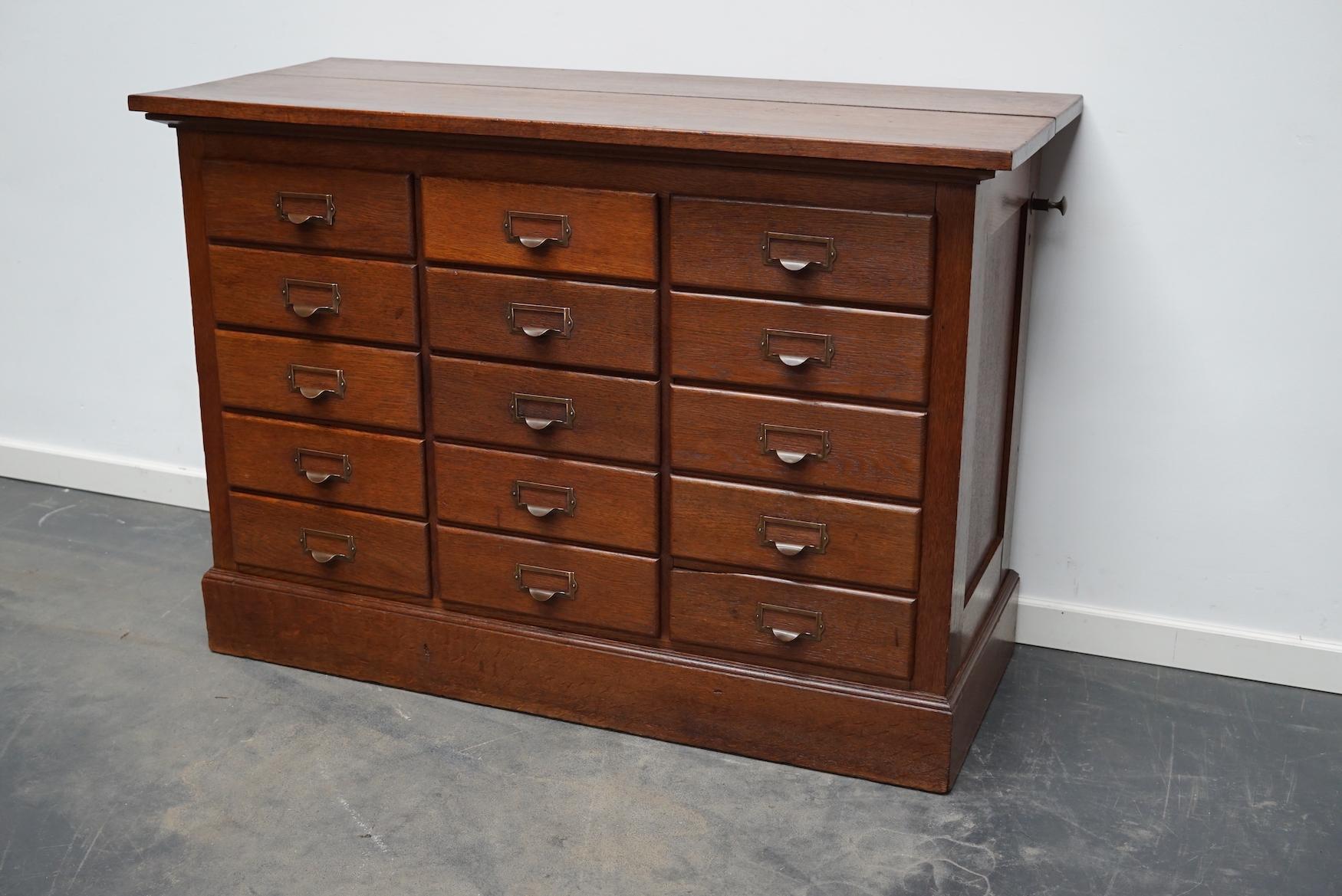 This apothecary cabinet was made circa 1930s in The Netherlands. It features 15 drawers with nice brass handles. The drawers can be locked with a central locking mechanism, most of the drawers lock but the original key is not present. It is made