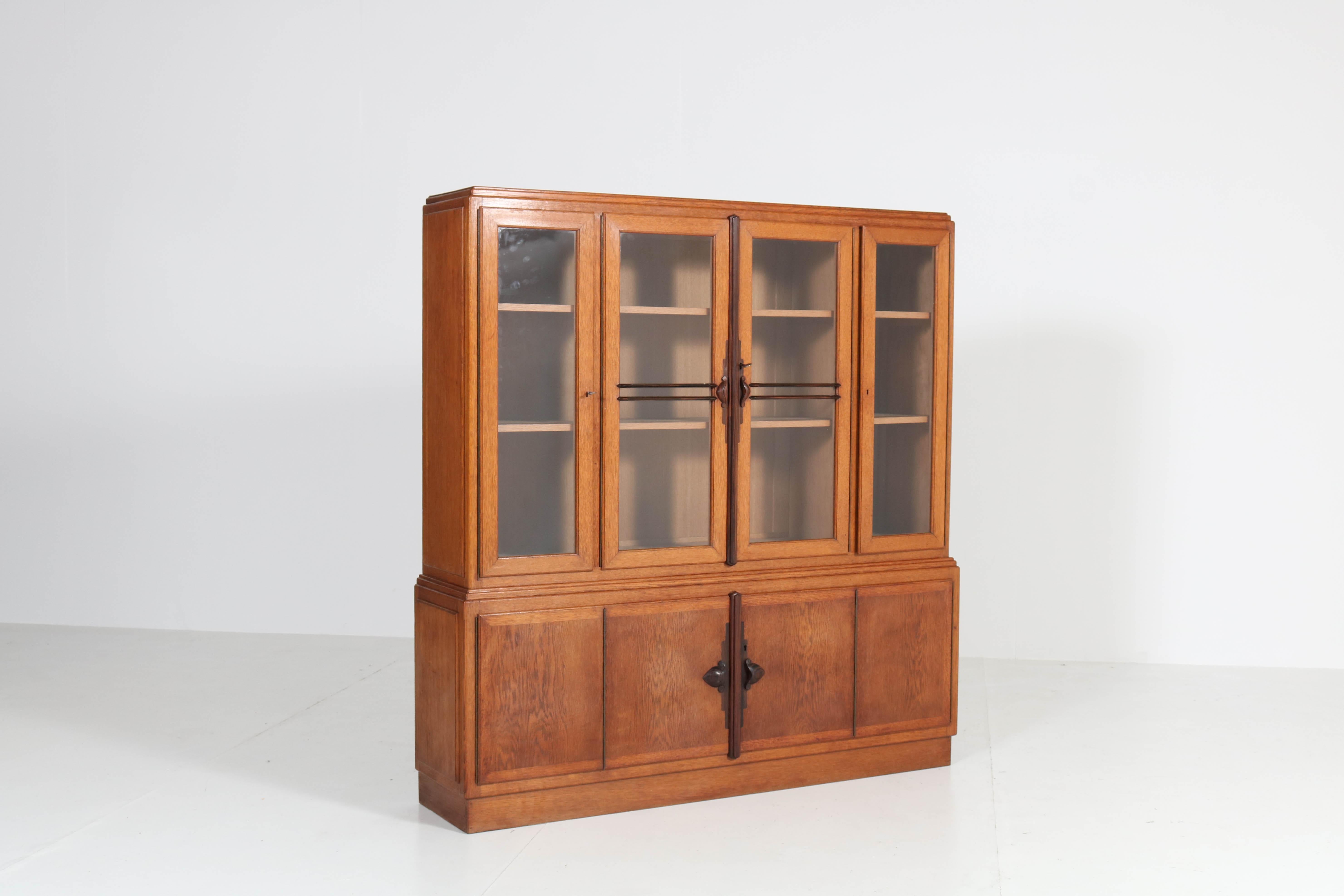 Wonderful and rare Art Deco Amsterdam School bookcase.
Striking Dutch design from the 1920s.
Solid oak and oak veneer with solid ebony Macassar handles and lining.
Six original solid oak shelves.
In very good condition with minor wear consistent