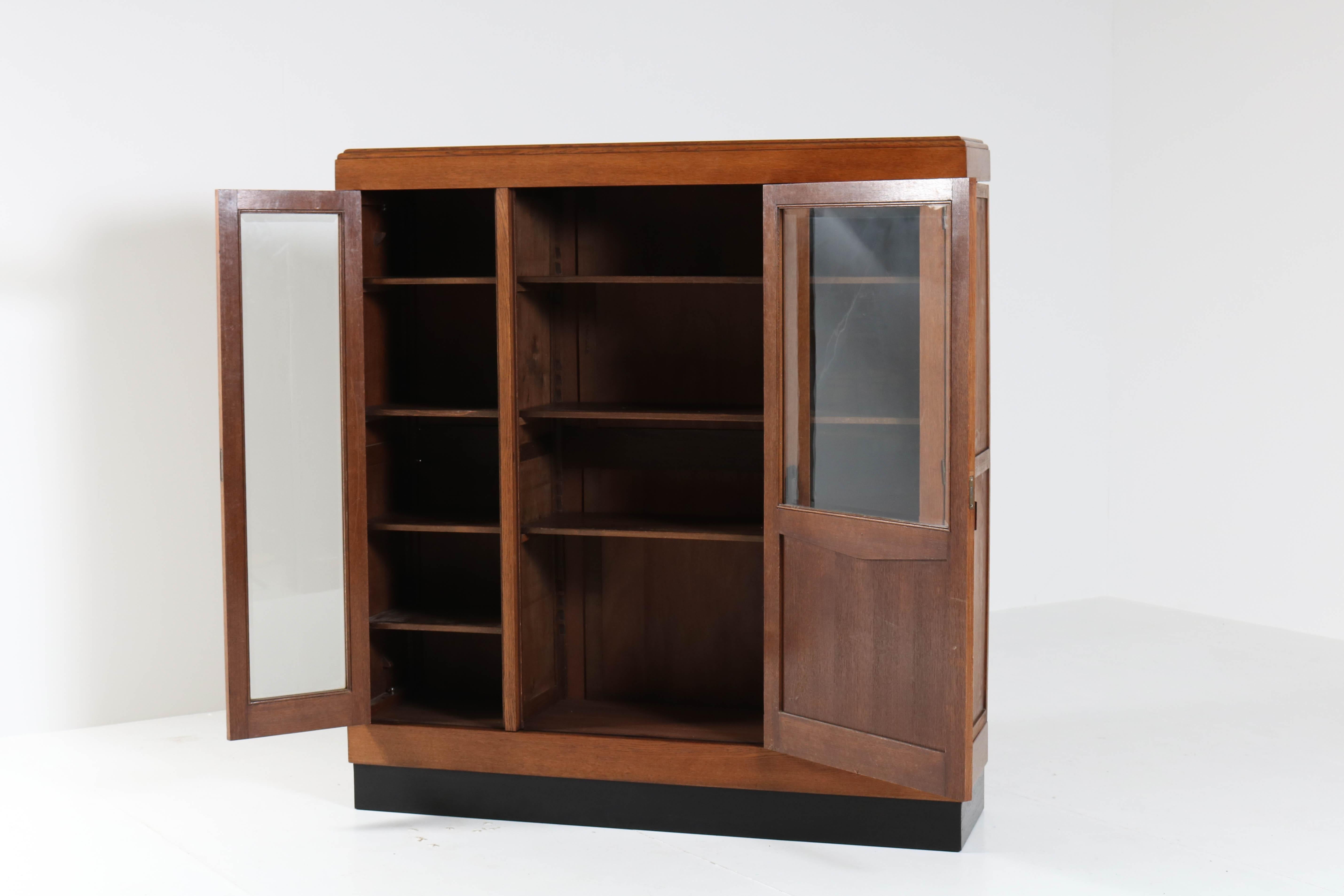 Wonderful Art Deco Haagse School bookcase with beveled glass.
Striking Dutch design from the twenties.
Oak with solid Macassar ebony handles.
Will be dismantled for safe transport.
Twelf wooden shelves,adjustable in height.
In good original