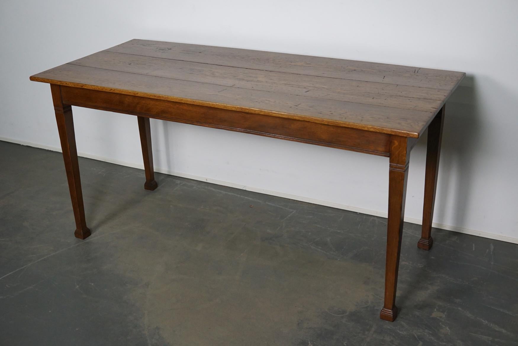This Dutch oak table was made around the 1920s-1930s in The Netherlands and spend it's early life in a bank. The table retained a very nice warm patina over the years. The leg room is 66 cm.
 