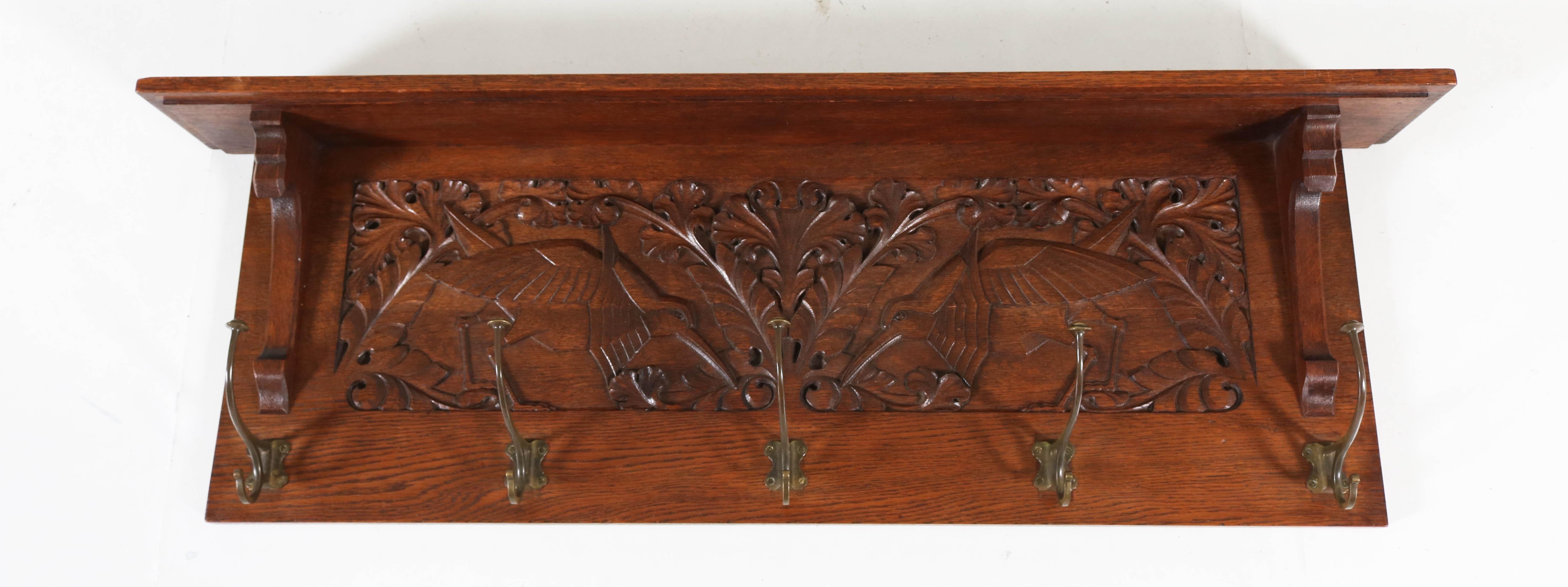 Stylish and rare Art Nouveau Arts & Crafts coat rack.
Striking Dutch design from the 1900s.
Magnificent hand carved birds.
Solid oak with five original brass hooks.
In good original condition with minor wear consistent with age and