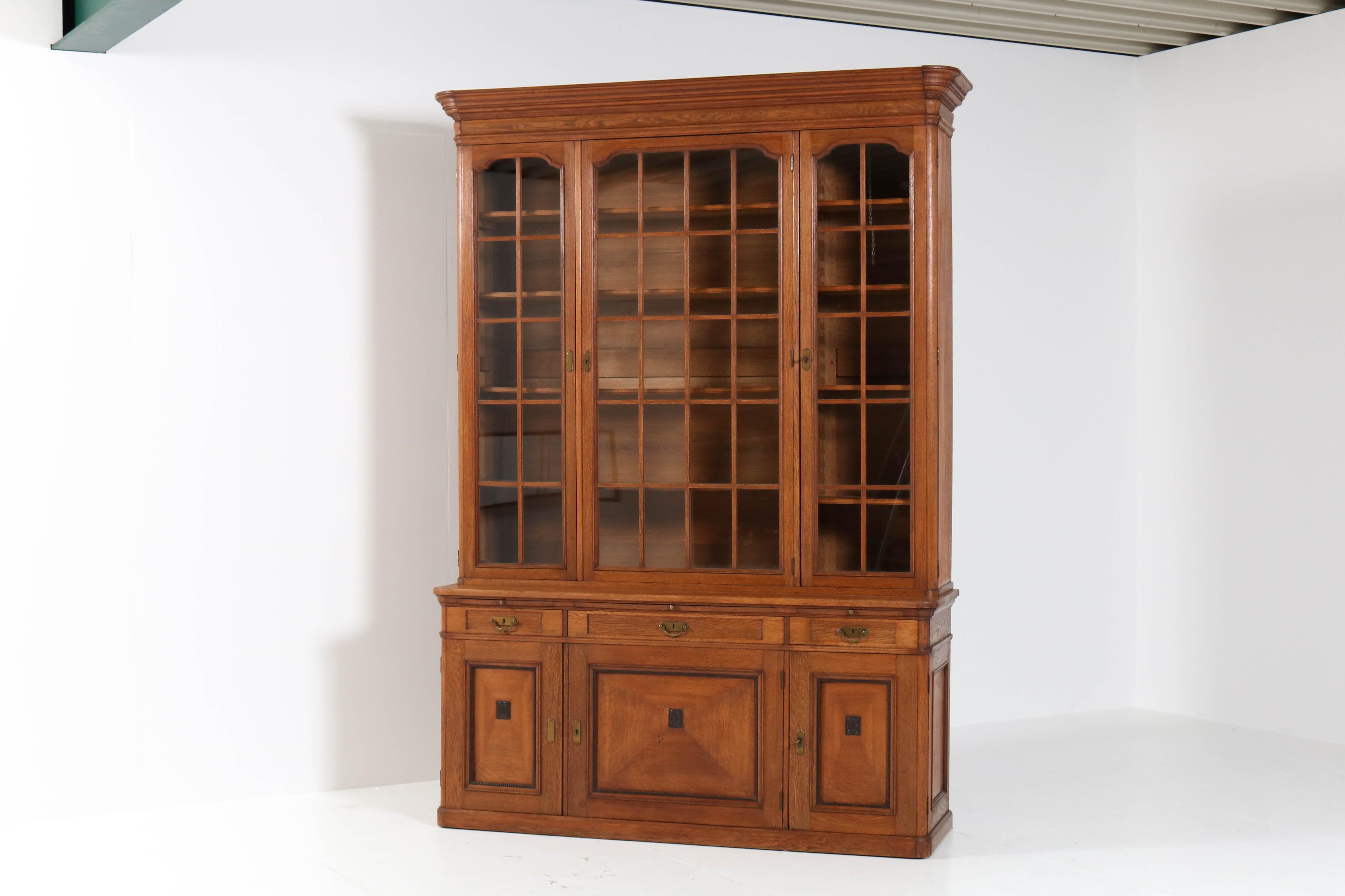 Stunning and rare Art Nouveau library bookcase.
Design by H. Pander & Zonen Den Haag.
Striking Dutch design from the 1900s.
Solid oak with original brass handles on the drawers.
Marked with metal tag,see image 15 and on one key.
This wonderful