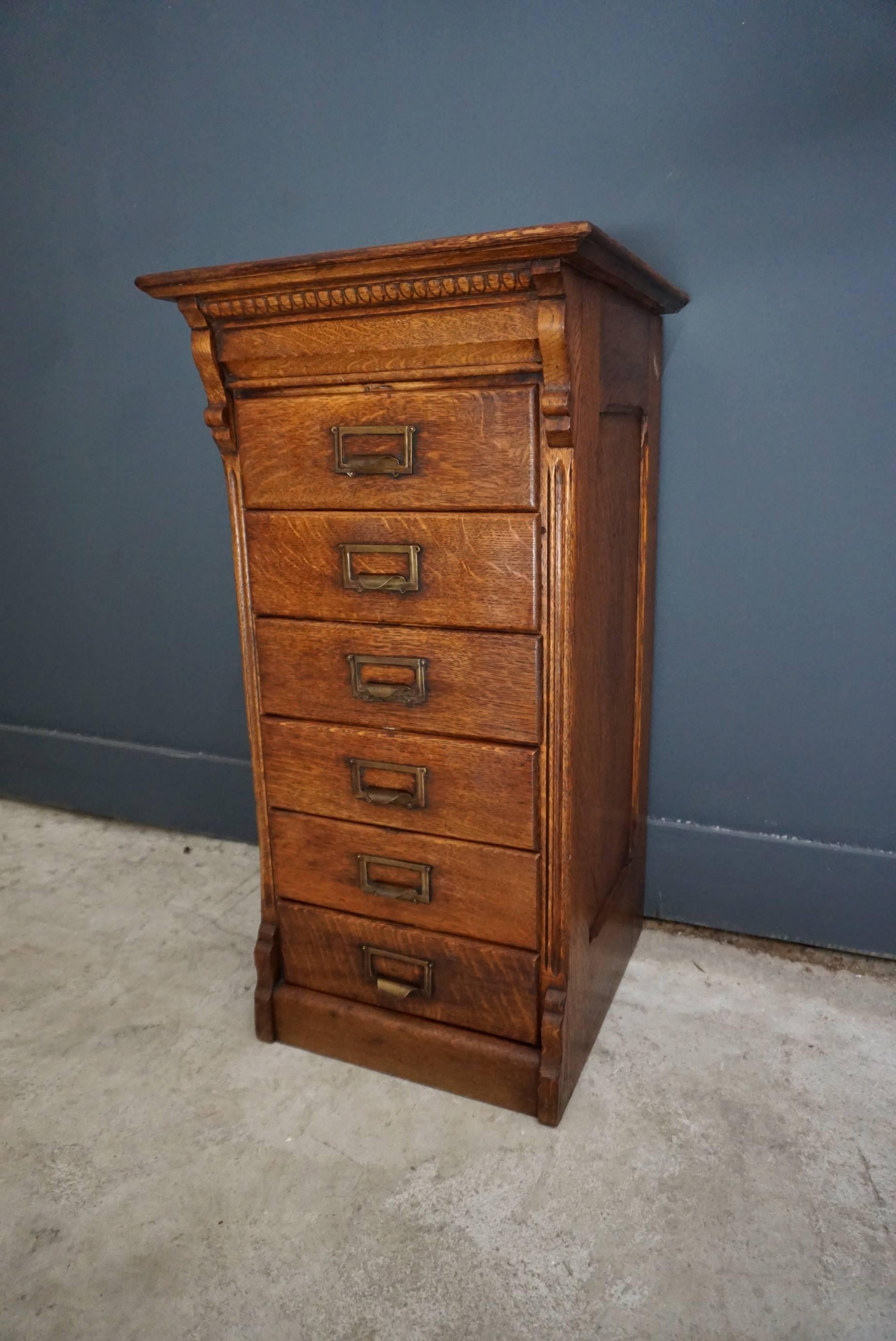 This oak filing cabinet was designed and made circa 1930 in The Netherlands. It features 6 drawers with brass hardware. The inside of the drawers measure: 32.5 x 26.5 x 7.5 cm.