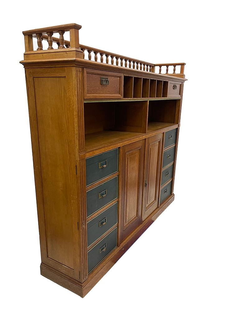 Armadio notarile in Oak, 1900-1920

Antico grande armadio notarile o Cartonnière con 8 scatole d'archivio, rivestito in pelle verde e stampa dorata. Una galleria traforata sulla parte superiore del mobile. Il piano è composto da 2 cassetti e sei