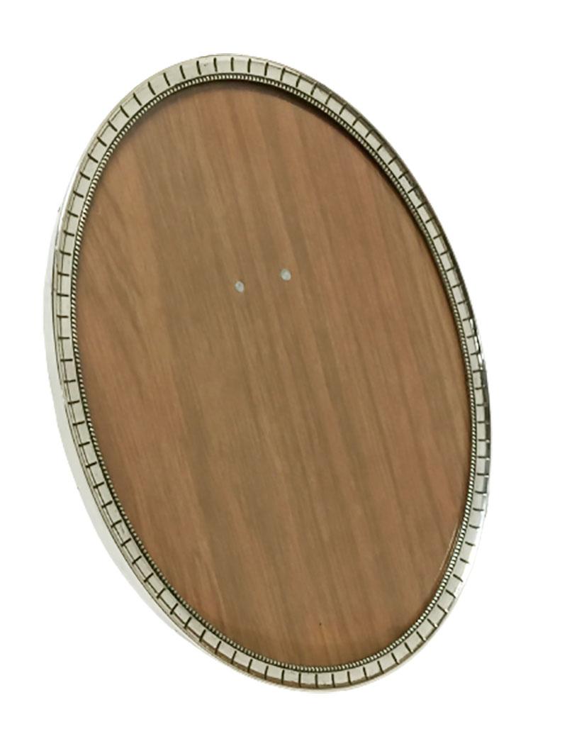 A Dutch oval silver photo frame 

Made by Vos, Dirk & Izaak & Schoorl, Aldert (Vos & Co n.v. Jacques)
Master sign is V.S. in double circle (1915-1920)
Dutch Silver hallmark 