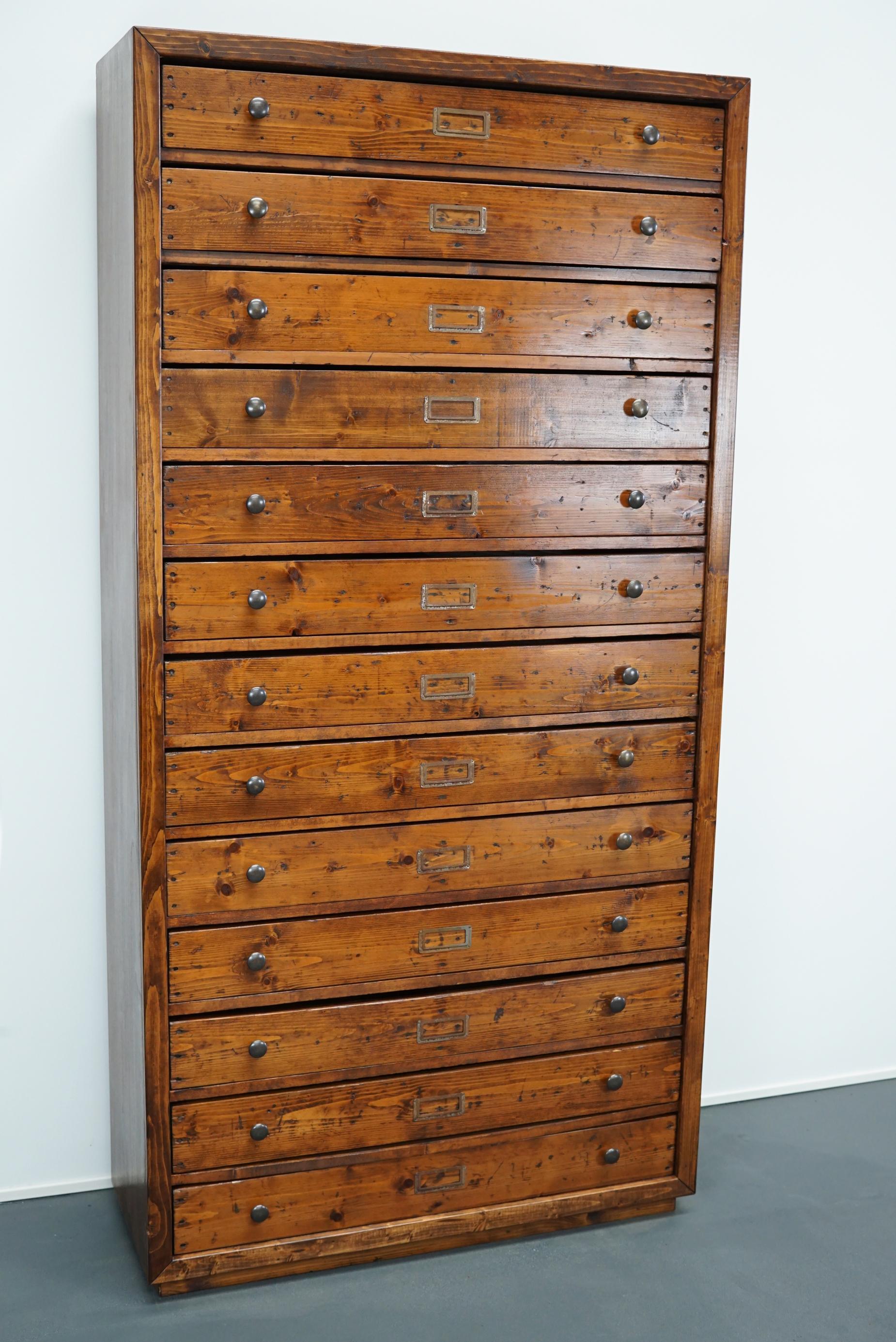 This cabinet was designed and made circa 1940s in the Netherlands. The cabinet features 13 large drawers and is 2 meters tall. It is made of pine with metal hardware. The cabinet is in a good vintage condition and completely restored. The inside