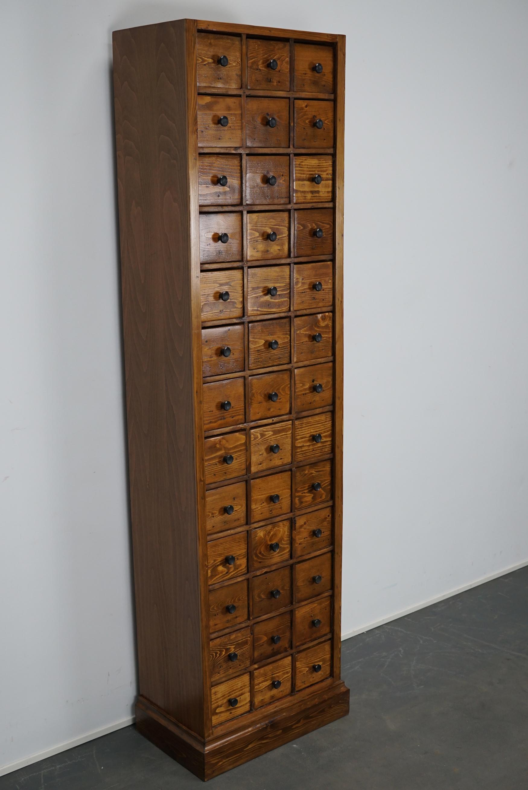 This apothecary cabinet of drawers was designed, circa 1950s in the Netherlands. The piece is made from pine and features 39 drawers with metal hardware. The interior dimensions of the drawers are: D 25 x W 11.5 x H 11 cm.
