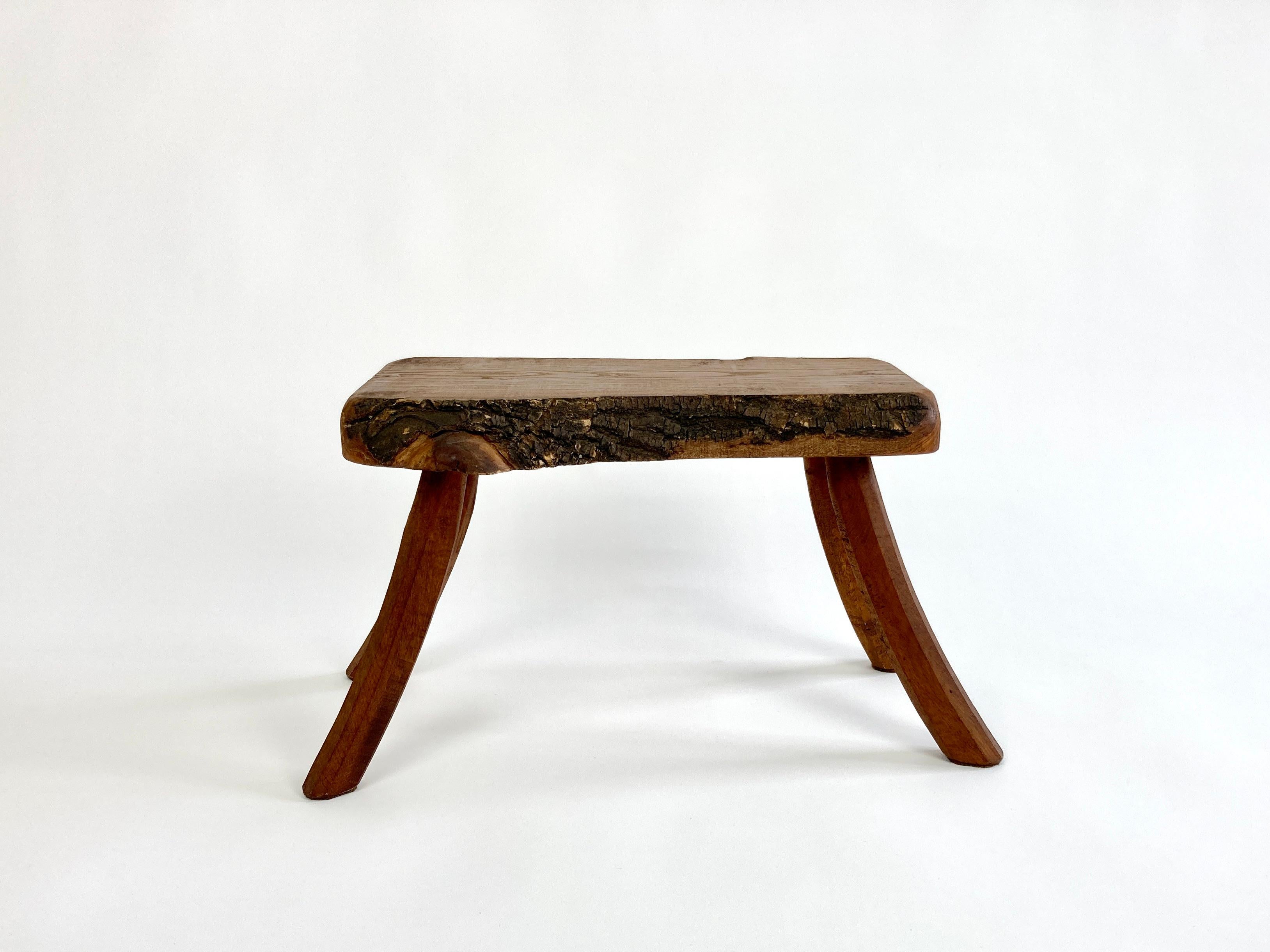 Mid 20th century primitive stool / side table from the Netherlands with a raw natural live bark edge top and gently curved legs. 

Well built and well proportioned, would make a great little low/side table.

Made of hardwoods (oak, possibly