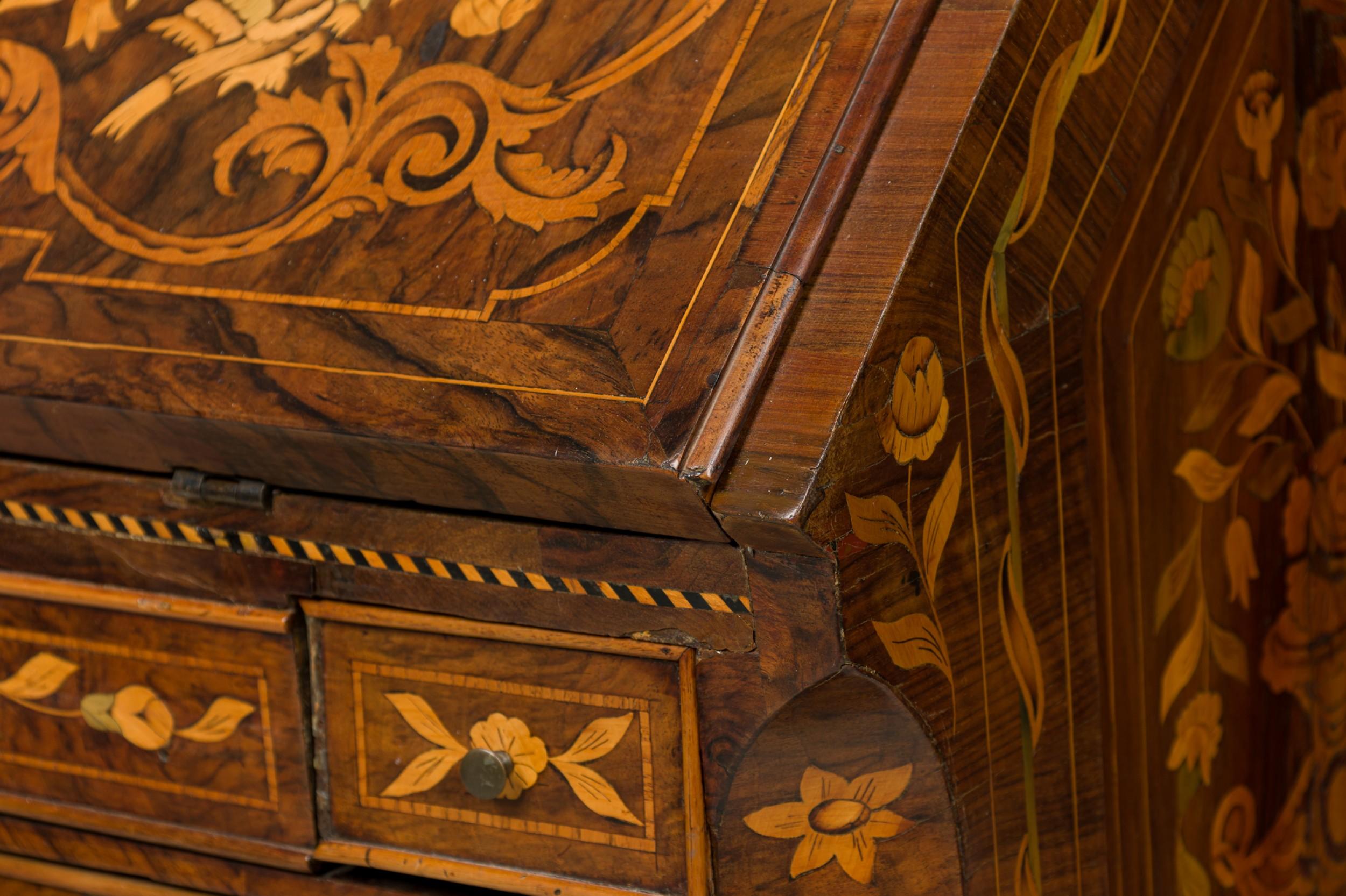 Dutch Rococo (Late 18th Century) drop front desk / secretary with elaborate foliate marquetry inlay, with the slant front folds down to create a desk surface with a green leather inset in front of a series of small drawers and compartments, over