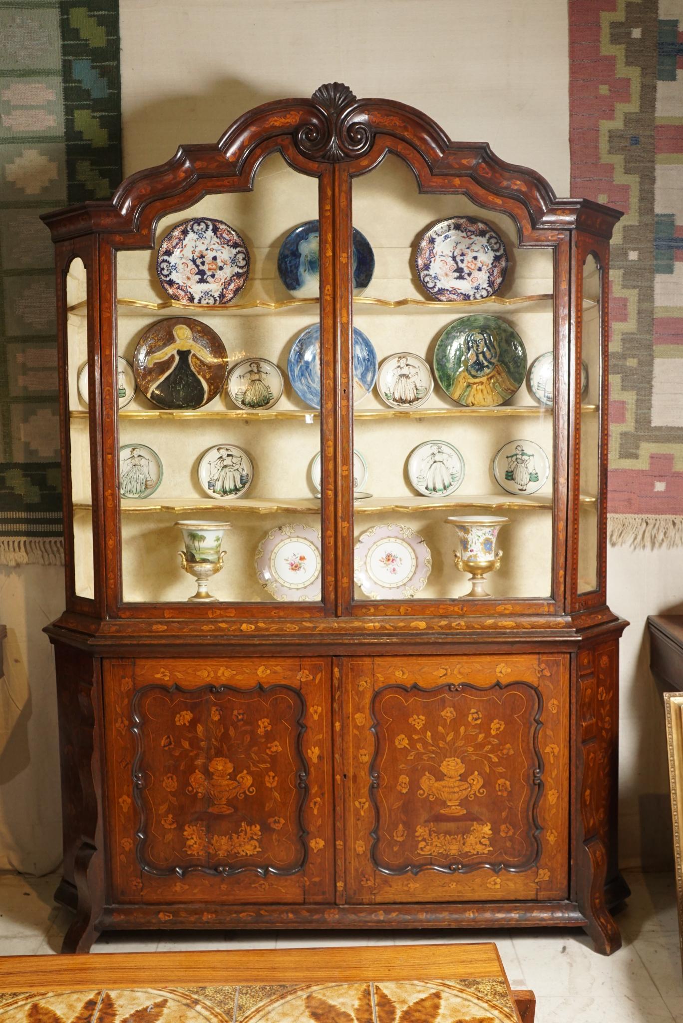 Dutch 18th century Rococo buffet or bookcase inlaid overall with floral marquetry. The buffet or bookcase with shaped, molded double scroll shell cornice over a glass fitted interior fitted with three shelves with gilded shaped fronts. The lower