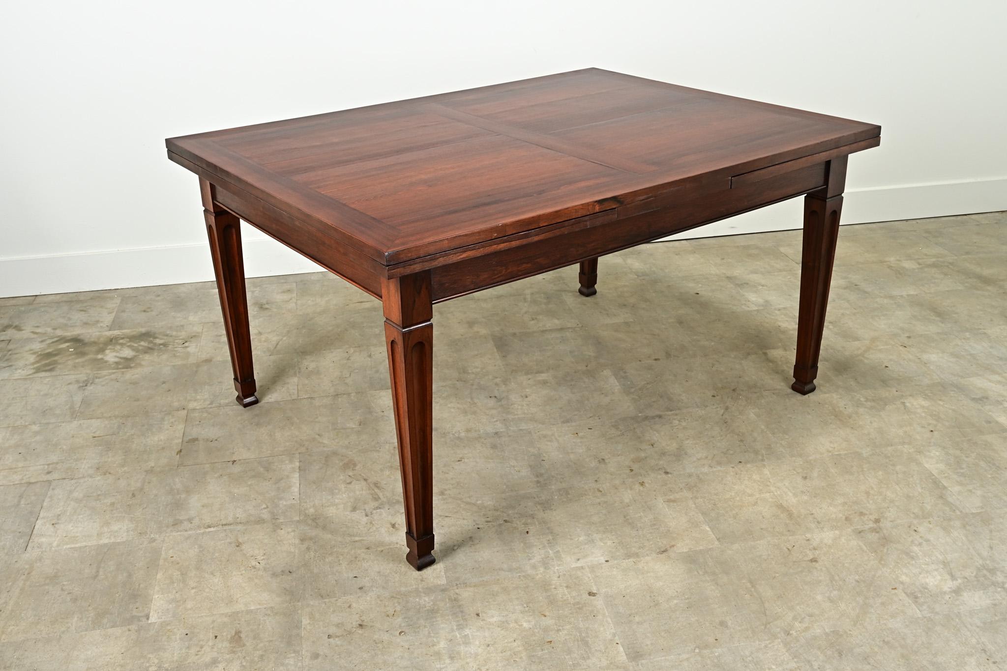 This rosewood extending dining table has self storing leaves making for a versatile dining table. This table easily seats six guests while closed and opens to seat up to ten. Cleaned and professionally refinished this table is ready for your