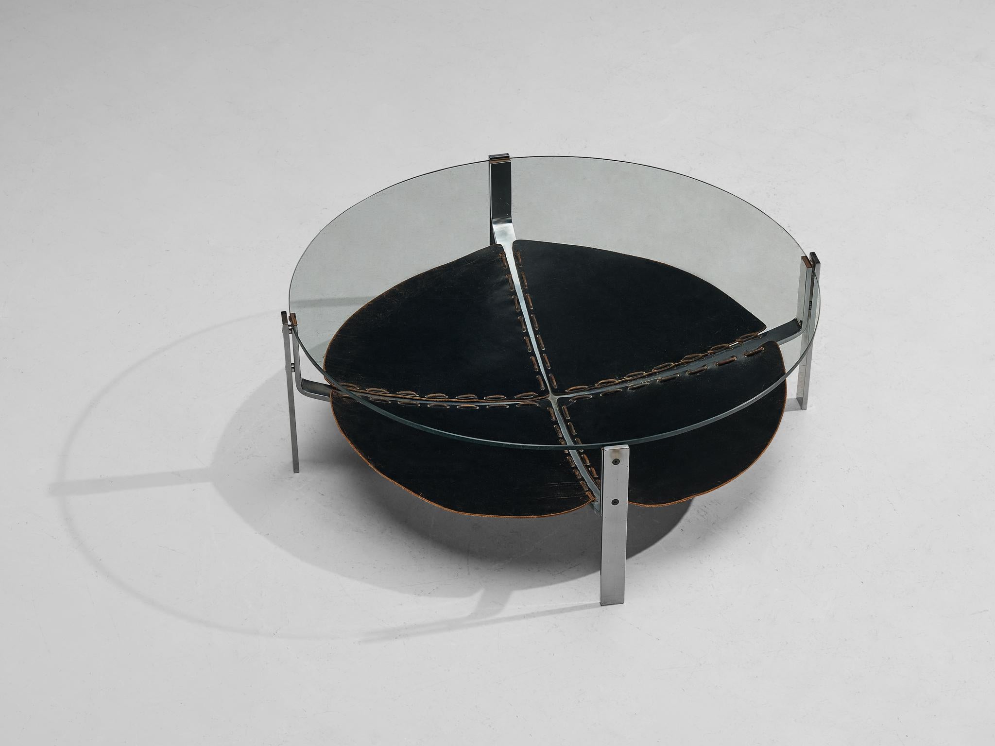 Round coffee table, chrome-plated steel, leather, glass, The Netherlands, 1970s

This round coffee table consist of a metal structure building the four legs. On the level below the glass tabletop, a beautifully patinated black leather 'shelve' is