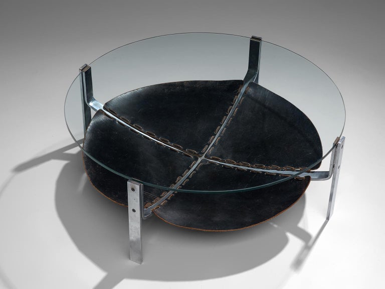 Round coffee table, steel, leather, glass, The Netherlands, 1970s

This round coffee table consist out of a metal structure building the four legs. On the level below the glass tabletop, a beautifully patinated dark brown leather 'shelve' is