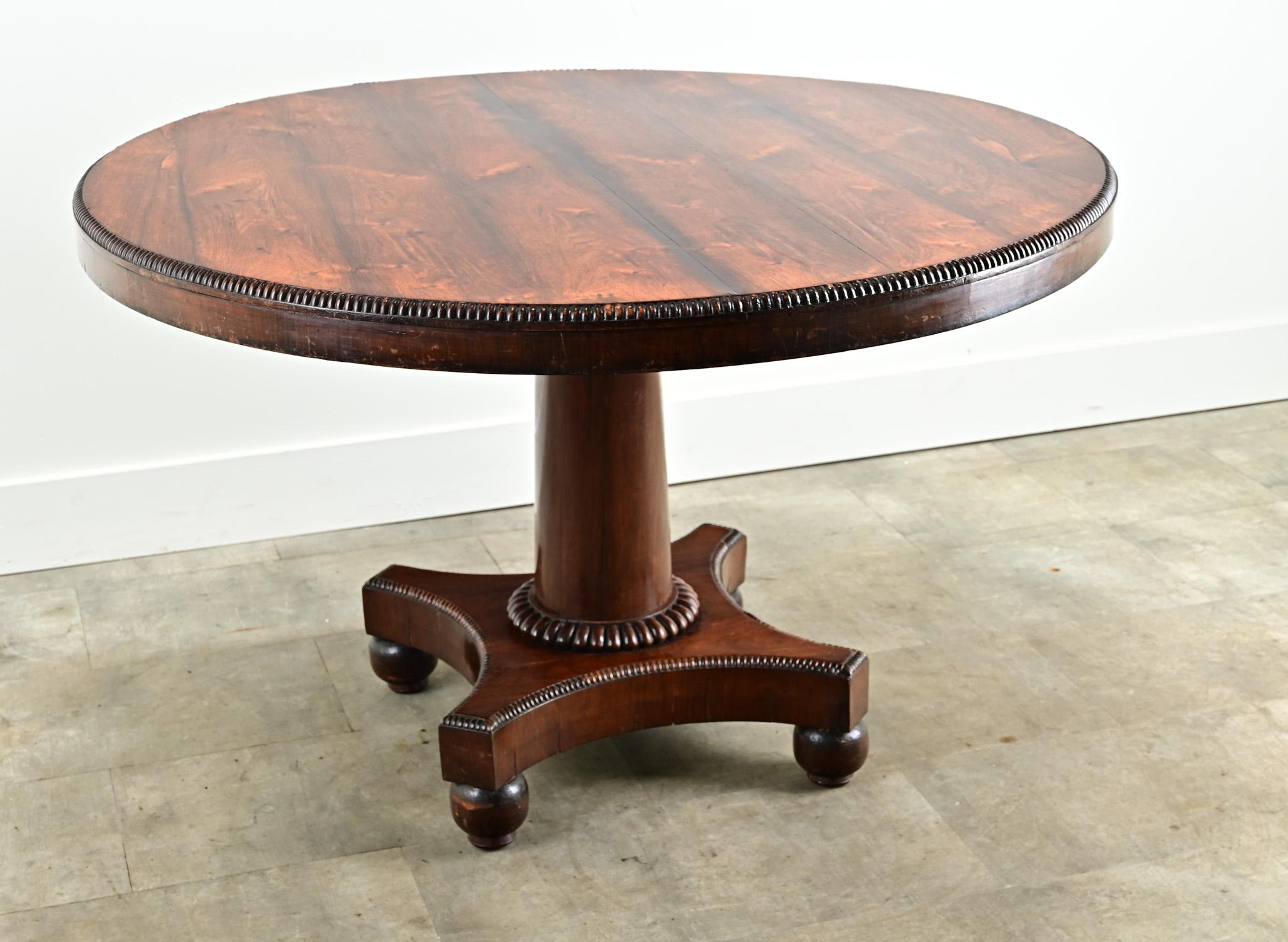 La table ronde idéale pour accueillir confortablement quatre personnes. Cette table hollandaise est fabriquée en bois de rose magnifiquement figuré, avec une bande perlée sculptée. La base du piédestal présente un style central simple et arrondi sur