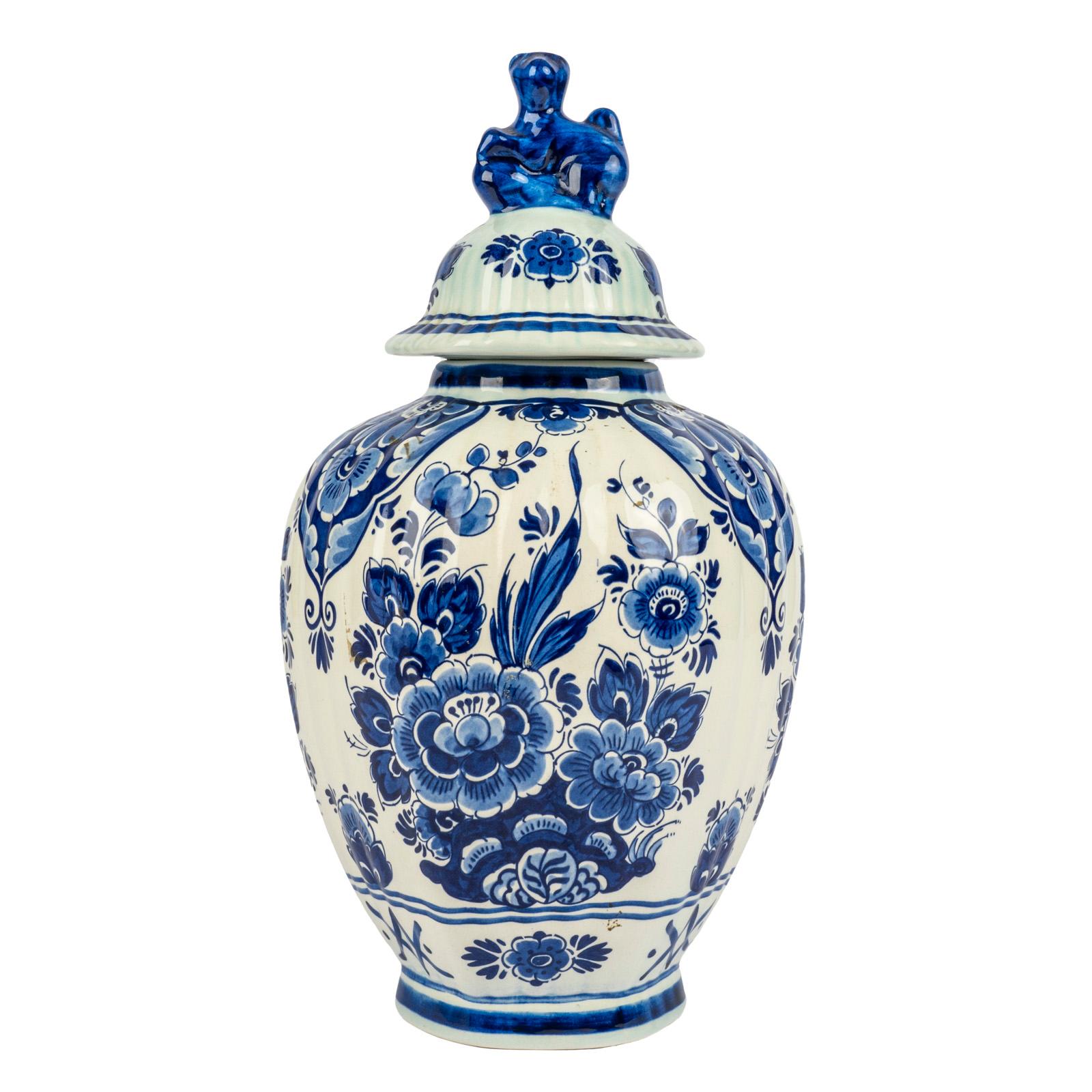 Guarnición de loza holandesa de Delft compuesta por un centro de mesa de jarrón de manto cubierto y un par de jarrones de perilla (3). Estos jarrones de forma acanalada están decorados con elegantes pavos reales, flores y follaje en brillantes