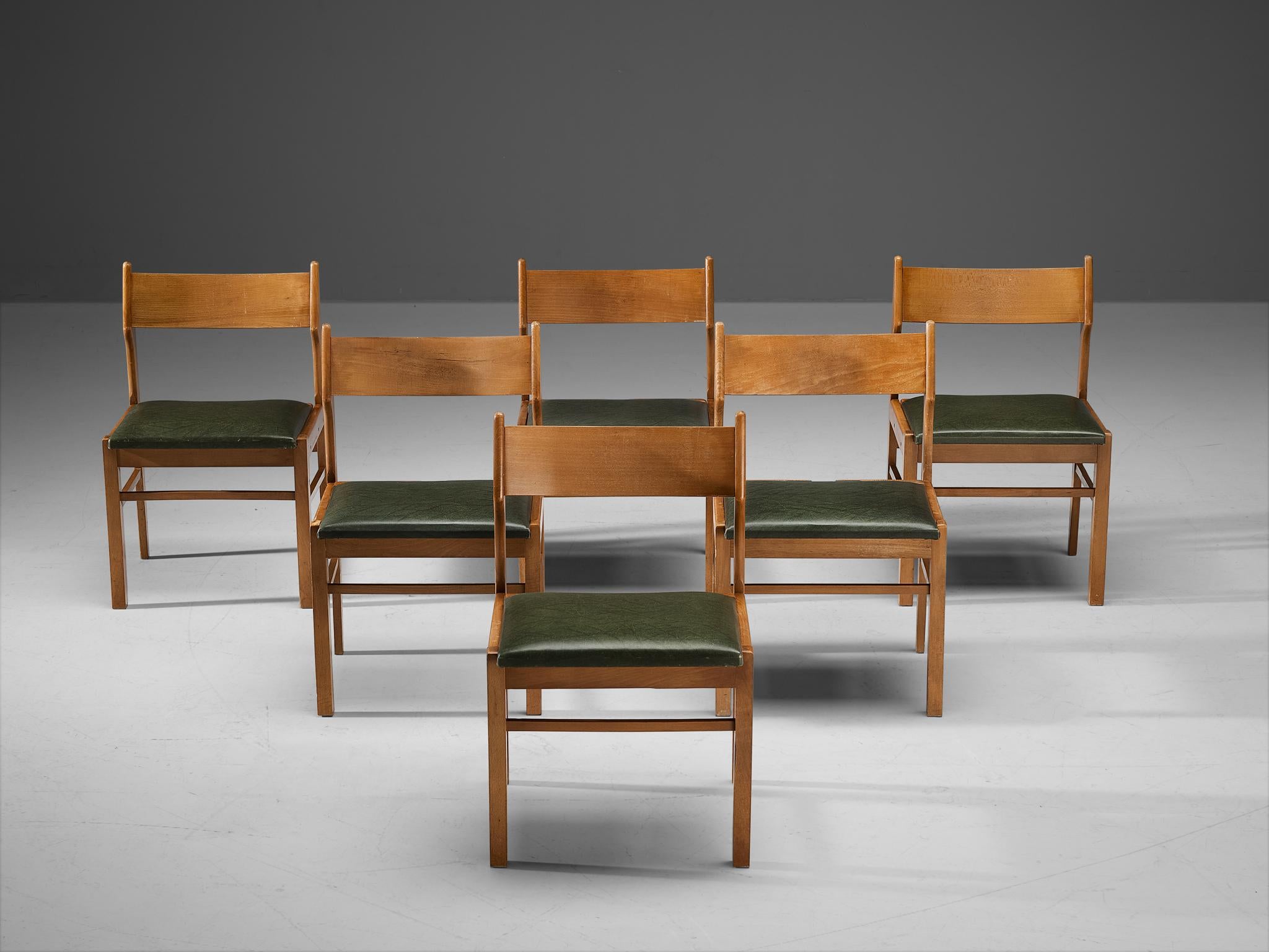 Dining chairs, wood, dark green leatherette, The Netherlands, 1960s. 

Modest set of six dining chairs. Its design shows clear lines and an open backseat. The dark green leatherette seats give a striking contrast with the warm color of the wooden