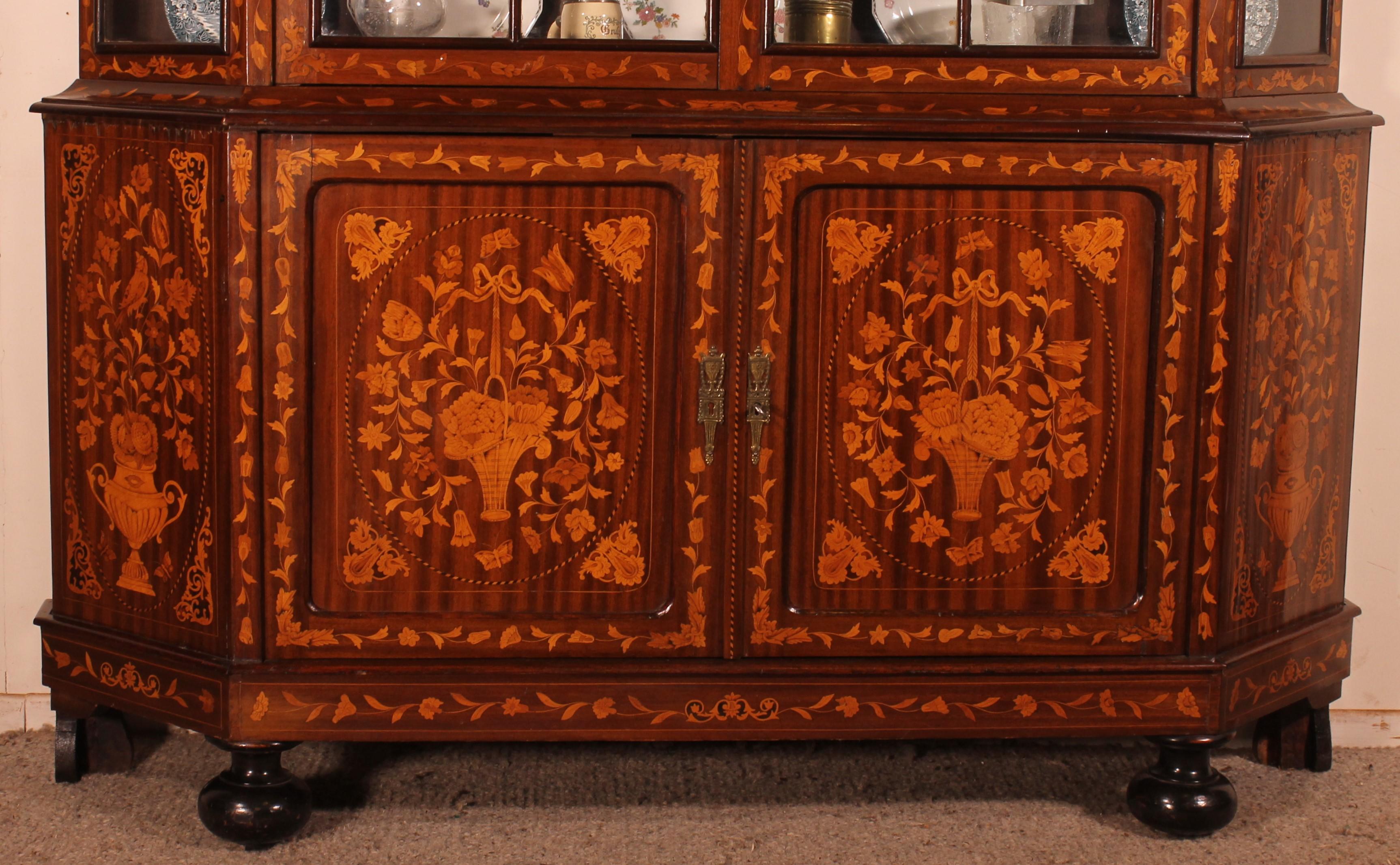 Superb Large Dutch vitrine or showcase cabinet in wood marquetry with floral decoration in mahogany, boxwood and precious wood from the 19th century

This rare vitrine has two solid doors at the bottom which is unusual since it is often composed of