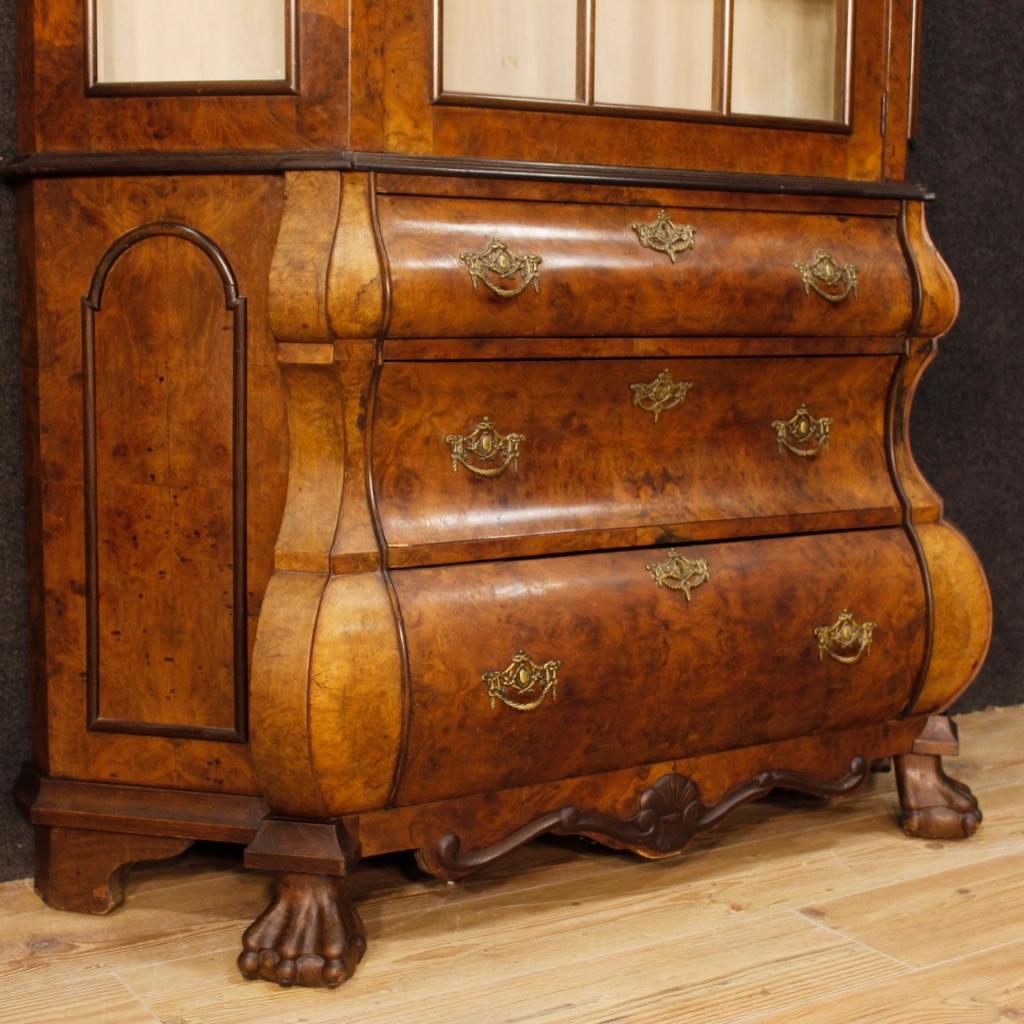 Dutch showcase from the mid-20th century. Double body cabinet in walnut, burl walnut, mahogany and oak of beautiful line and pleasant furnishings. Furniture supported by four feet of which two zoormorphic. Lower body with three external drawers of