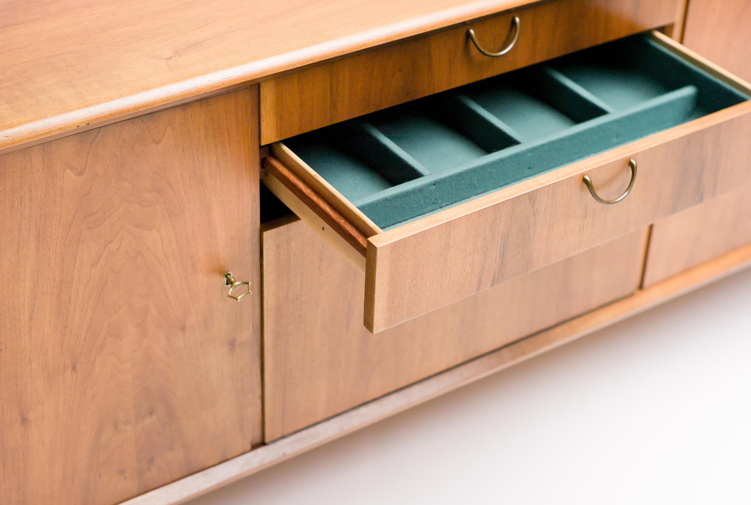 Sideboard in European walnut designed by the Dutch designer A. A. Patijn for Fristho. 
The doors and drawers have refined brass handles; the legs have height adjustable brass feet. 
The drawers have a beautiful bent plywood interior.
 